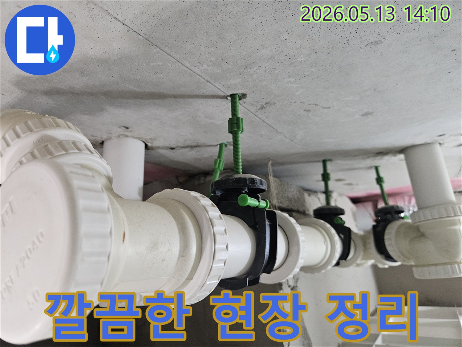 누수 공사 완료 후-콘크리트 천장 아래 배관과 밸브들이 깨끗하게 정돈된 작업 현장