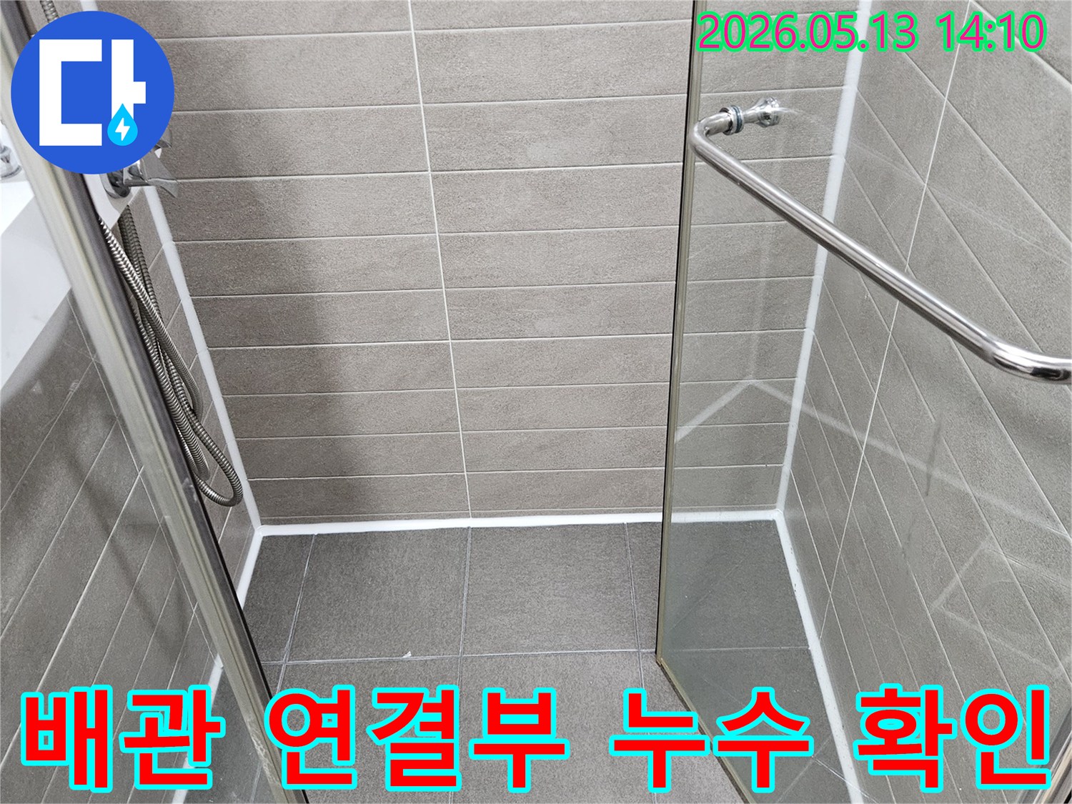 샤워실 내부의-배관 연결 부위와-주변 마감 상태를-정밀하게 점검하는 모습