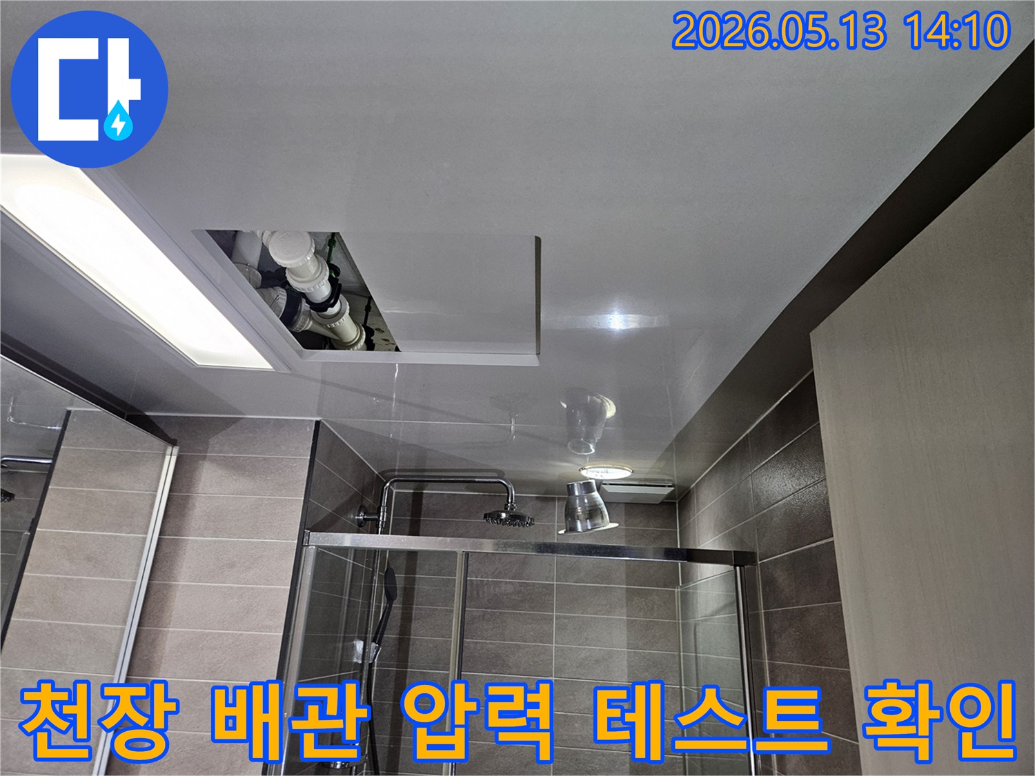 욕실 천장 내부의-수리된-배관에서-누수가-재발하지-않도록-압력-테스트를-진행하고-있는-전문가의-모습입니다