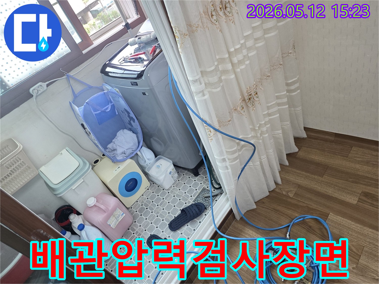 누수-탐지를-위해-세탁실-내부에서-배관에-압력-측정-장치를-연결하고-있는-모습