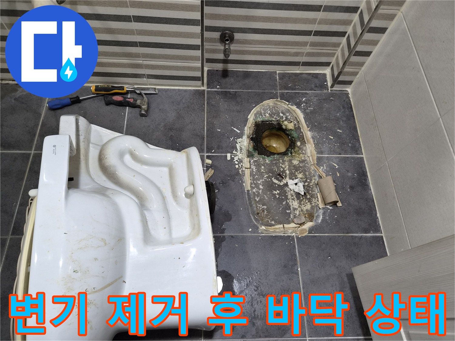 변기를 떼어낸 자리의 오수관과 젖은 바닥을 촬영한 사진입니다.