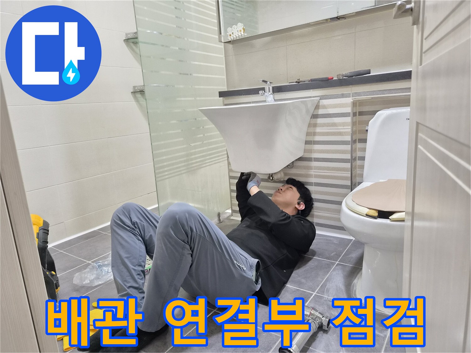 세면대 하단 트랩과 수전 연결 상태를 체크하는 작업자