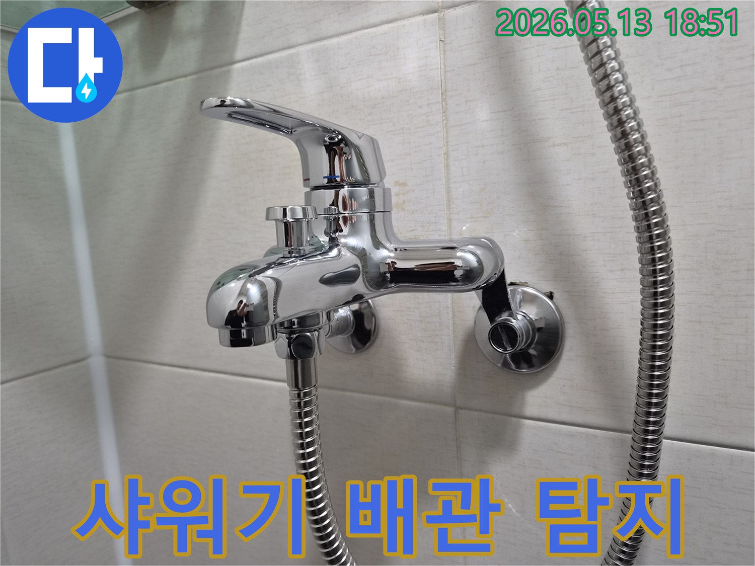 욕실 벽에 설치된 반짝이는 샤워 수전-아래로 연결된 샤워 호스-배관 누수 탐지를 위한 핵심 지점