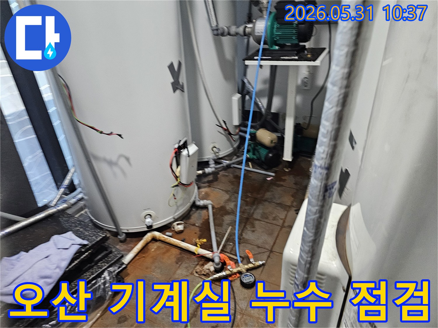 이 이미지는-오산-지역의-기계실에서-전문가가-다양한-배관의-누수-여부를-종합적으로-점검하고-있는-현장-모습을-보여줍니다.