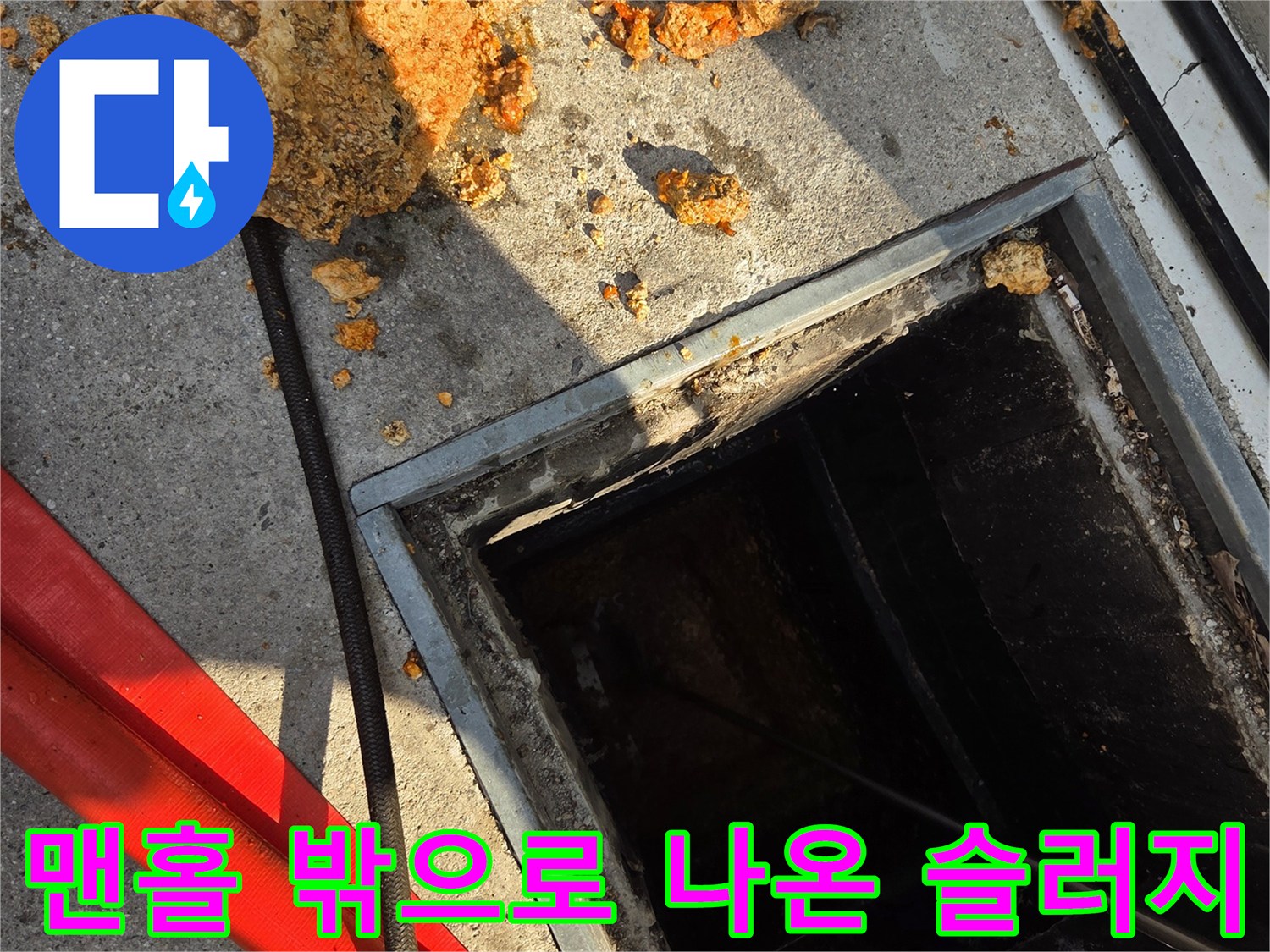 맨홀 주변에 쌓인 커다란 기름 덩어리와 세척용 호스
