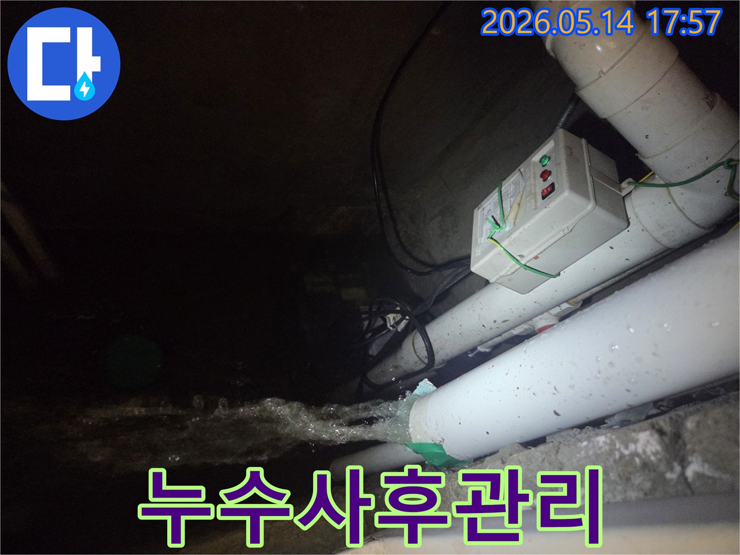 어두운 지하 공간에서-파이프에서 물이 강하게 뿜어져 나오는-누수 현장을 보여주는 사진입니다-전기 제어 박스와 배관들이 함께 보입니다.