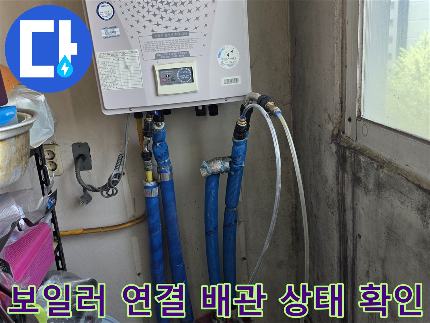 보일러 아래쪽 파란색과 흰색 호스가 복잡하게 연결된 모습