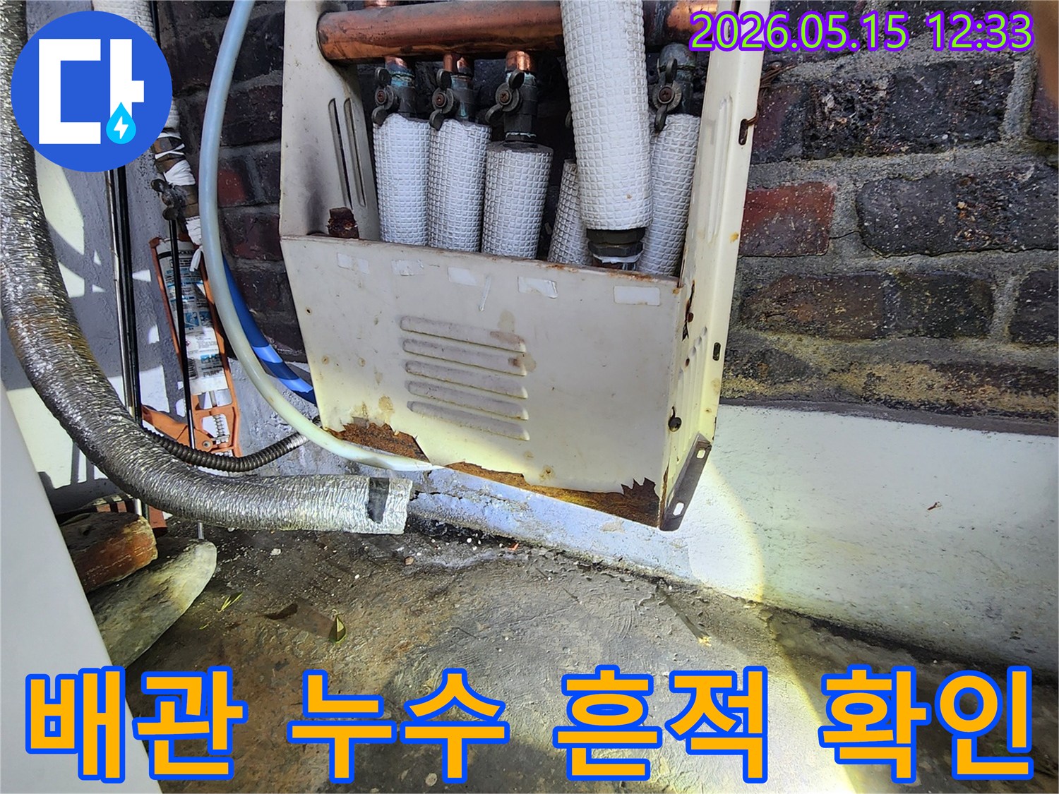 누수 엔지니어가-오랜 사용으로 부식된-배관 주변의-누수 흔적을-정밀하게 확인하며-누수 지점을-파악하는 모습입니다