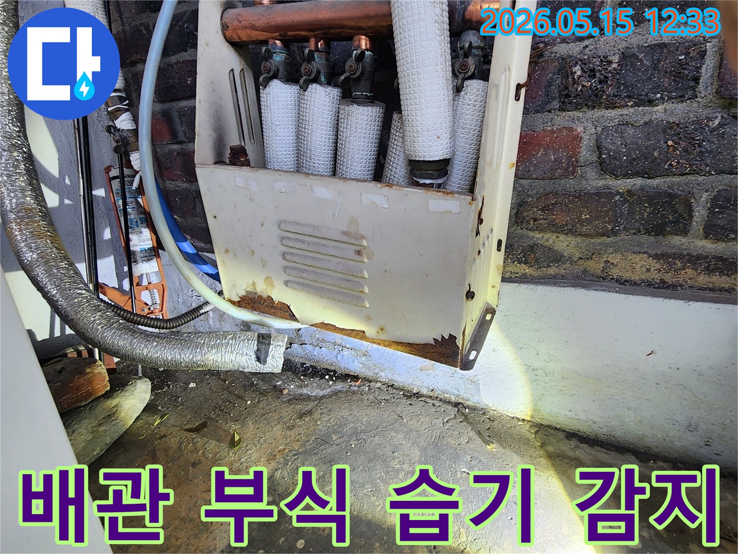 누수 엔지니어가-오랜 사용으로 부식된-배관 주변의-습기 흔적을-정밀하게 감지하며-누수 지점을-파악하는 모습입니다