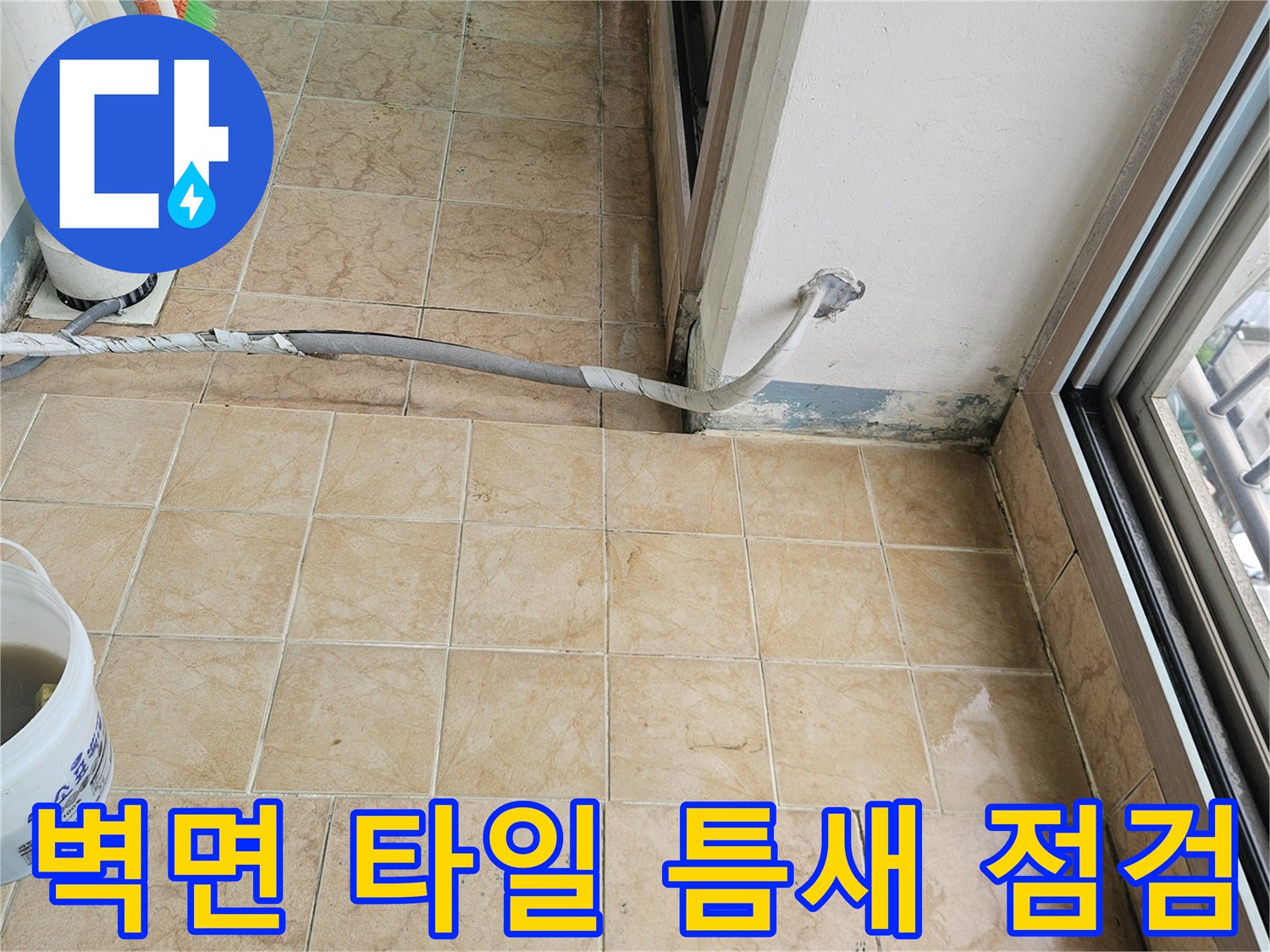 아파트 베란다-타일 줄눈 사이의 균열과 오염된 벽면 상태를 정밀하게 관찰하는 장면