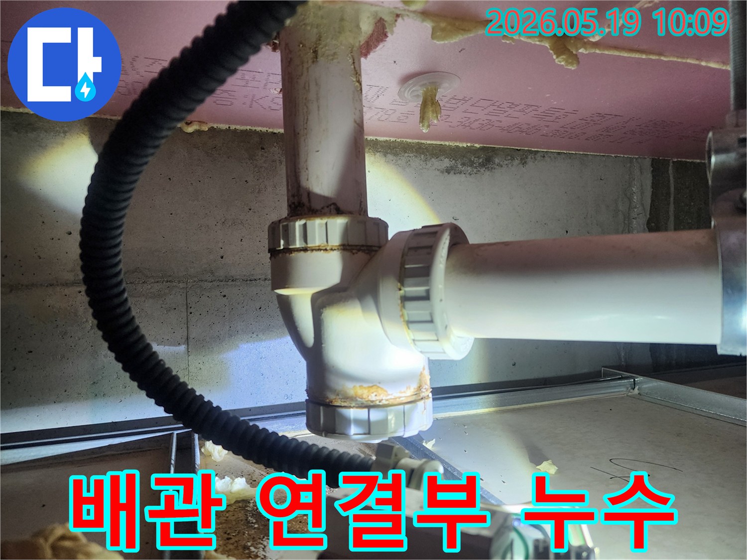 누수 엔지니어가 배관 연결부의 부식과 물기 흔적을 확인하며-누수 지점을 정확히 파악하기 위한 진단 작업을 수행하고 있습니다
