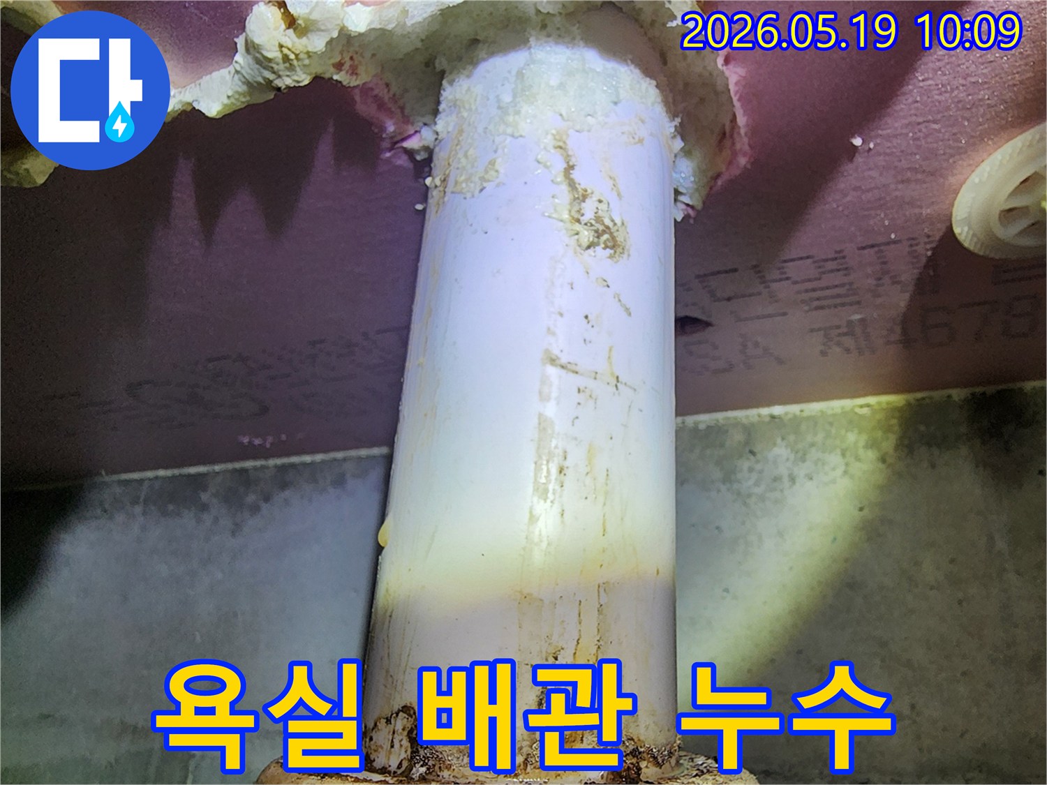 이 이미지는 욕실 배관에서 발생한 누수로-주변이 젖고 오염된 모습을 보여줍니다