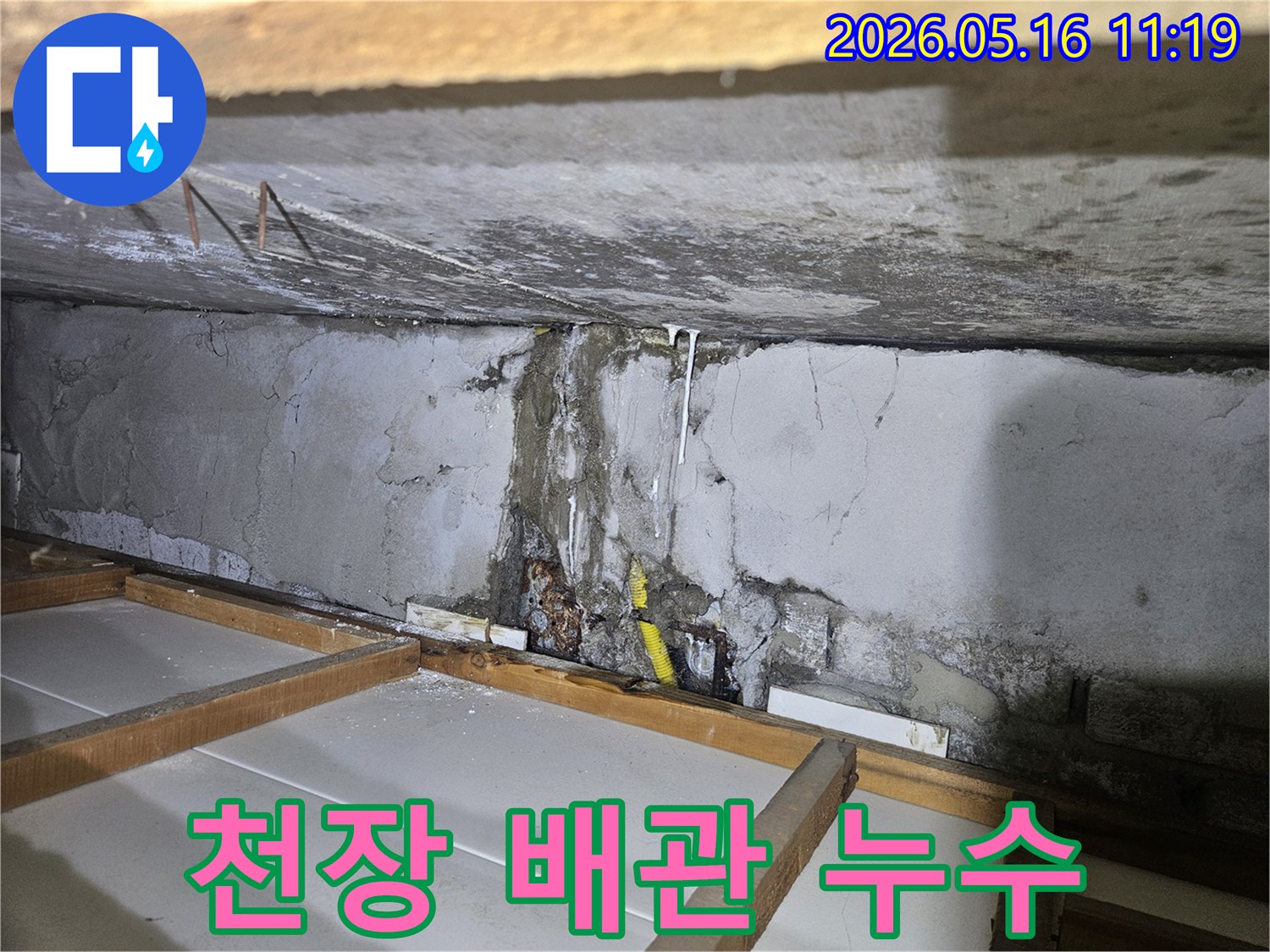 천장 콘크리트 벽면에서-물이 새어 흘러내린-누수 흔적과 함께-노출된 배관 주변의 모습