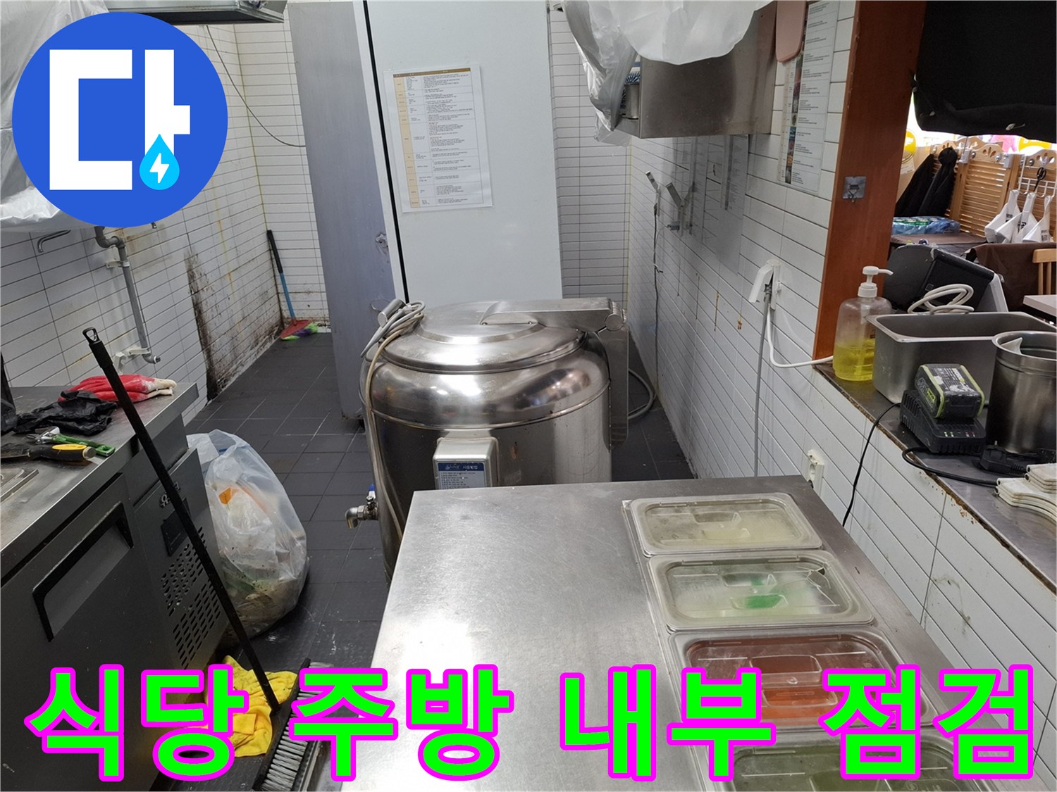 하얀색 타일 벽면과 스테인리스 조리 설비가 있는 주방 현장