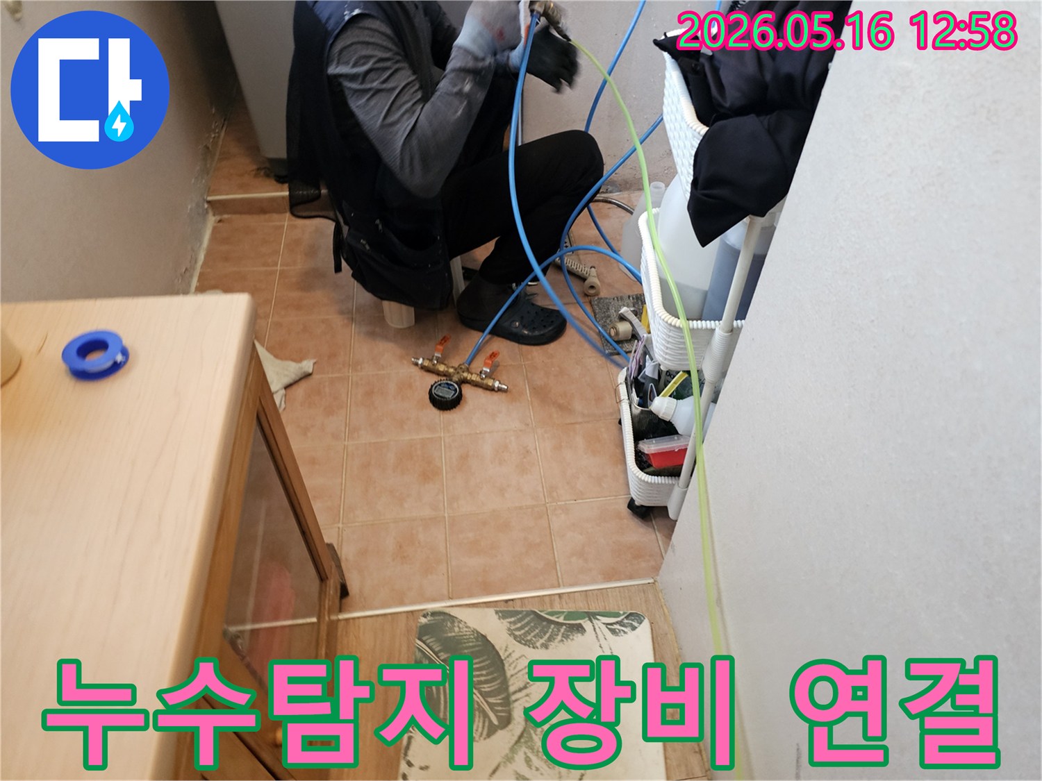 누수-전문가가-누수-탐지를-시작하기-위해-압력-테스트-장비를-배관에-연결하는-모습