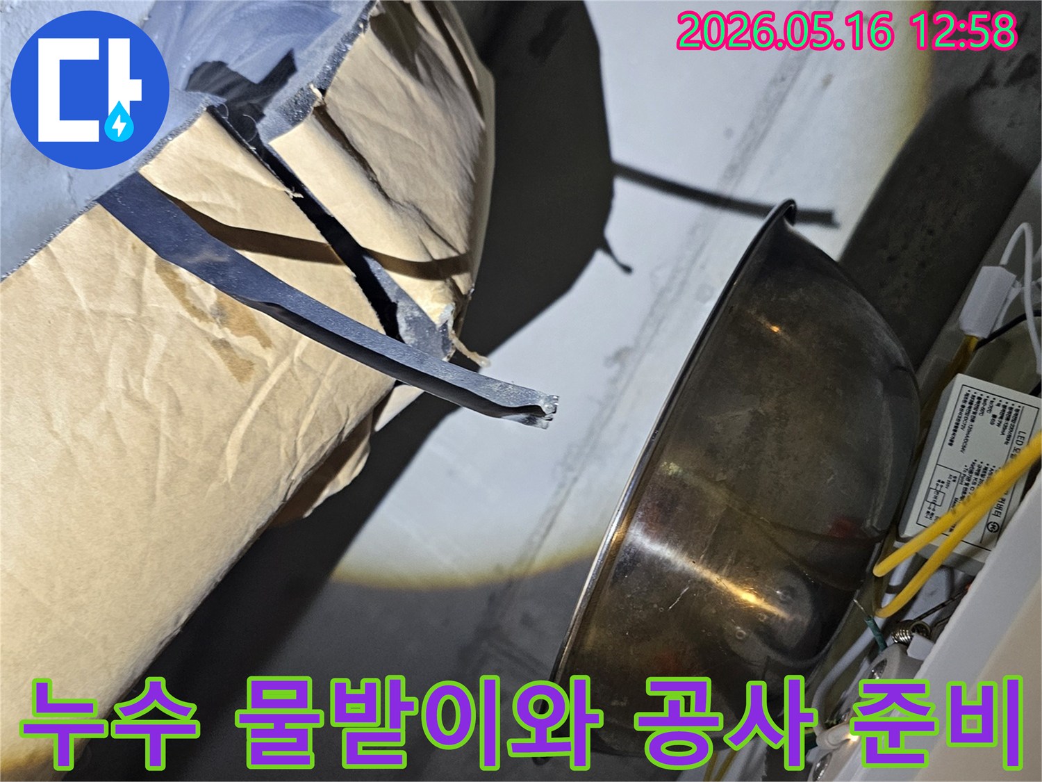 누수-지점에서-떨어지는-물을-임시로-받아내는-금속-그릇과-주변-공사-자재