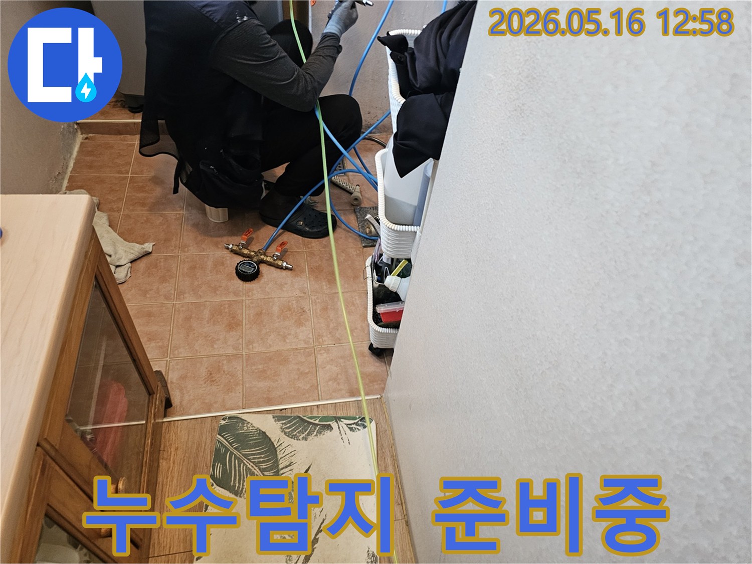 누수-탐지-전문가가-압력-측정-장비를-점검하며-누수-지점을-찾는-작업-사진