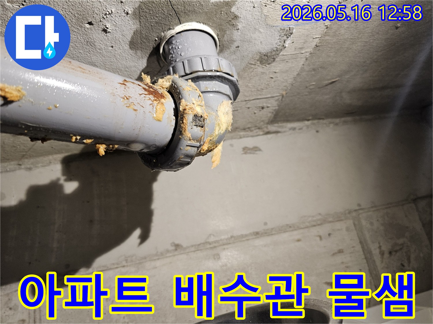 아파트-천장-아래-배수관-연결부에서-물이-새어-나와-단열재가-젖은-모습을-보여주는-누수-현장-사진