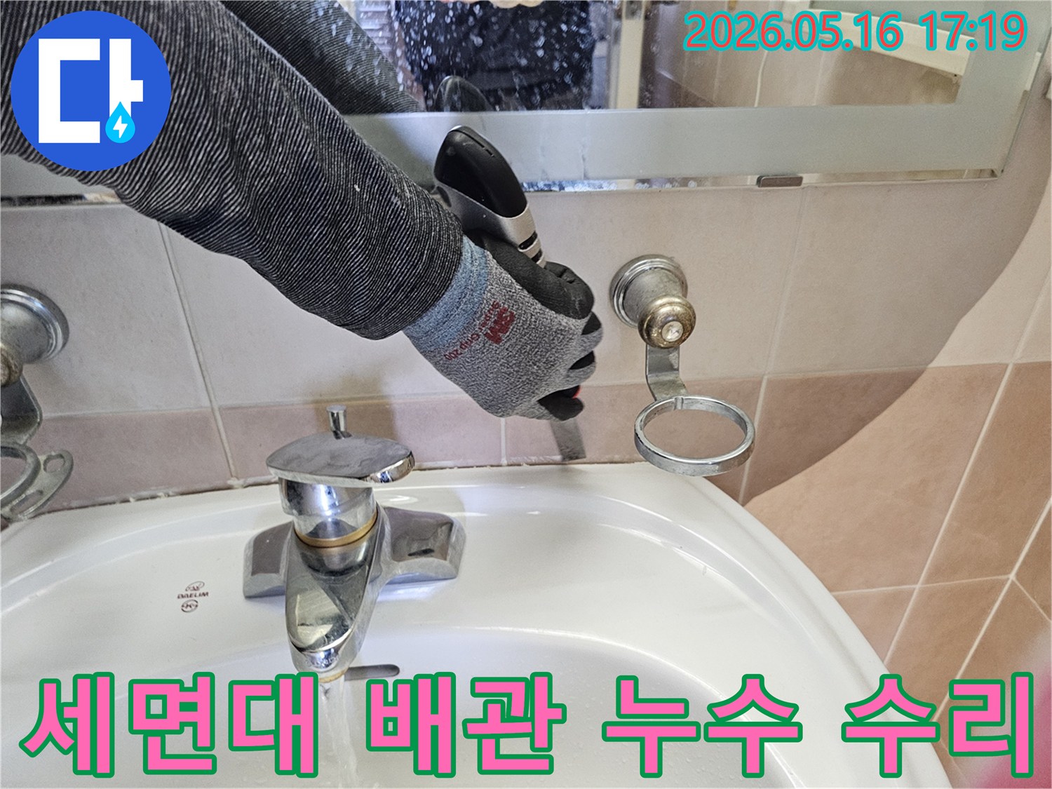전문 기술자가-안전 장갑을 착용한 채-욕실 세면대 수도꼭지 주변의-누수 배관을-정성껏 수리하고 있습니다.