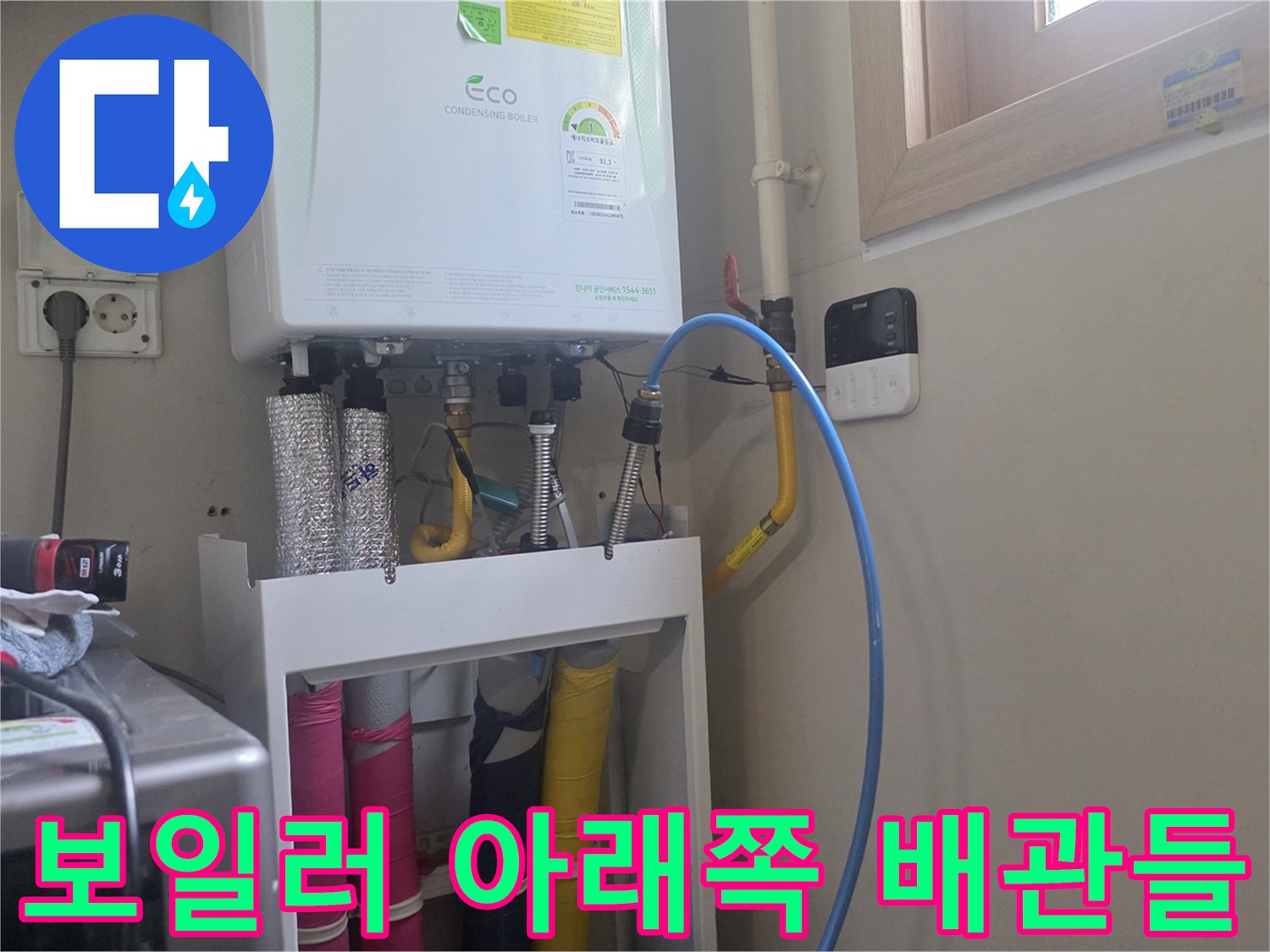 보일러 하단부의 다양한 색상 보온재가 씌워진 배관 연결 부위