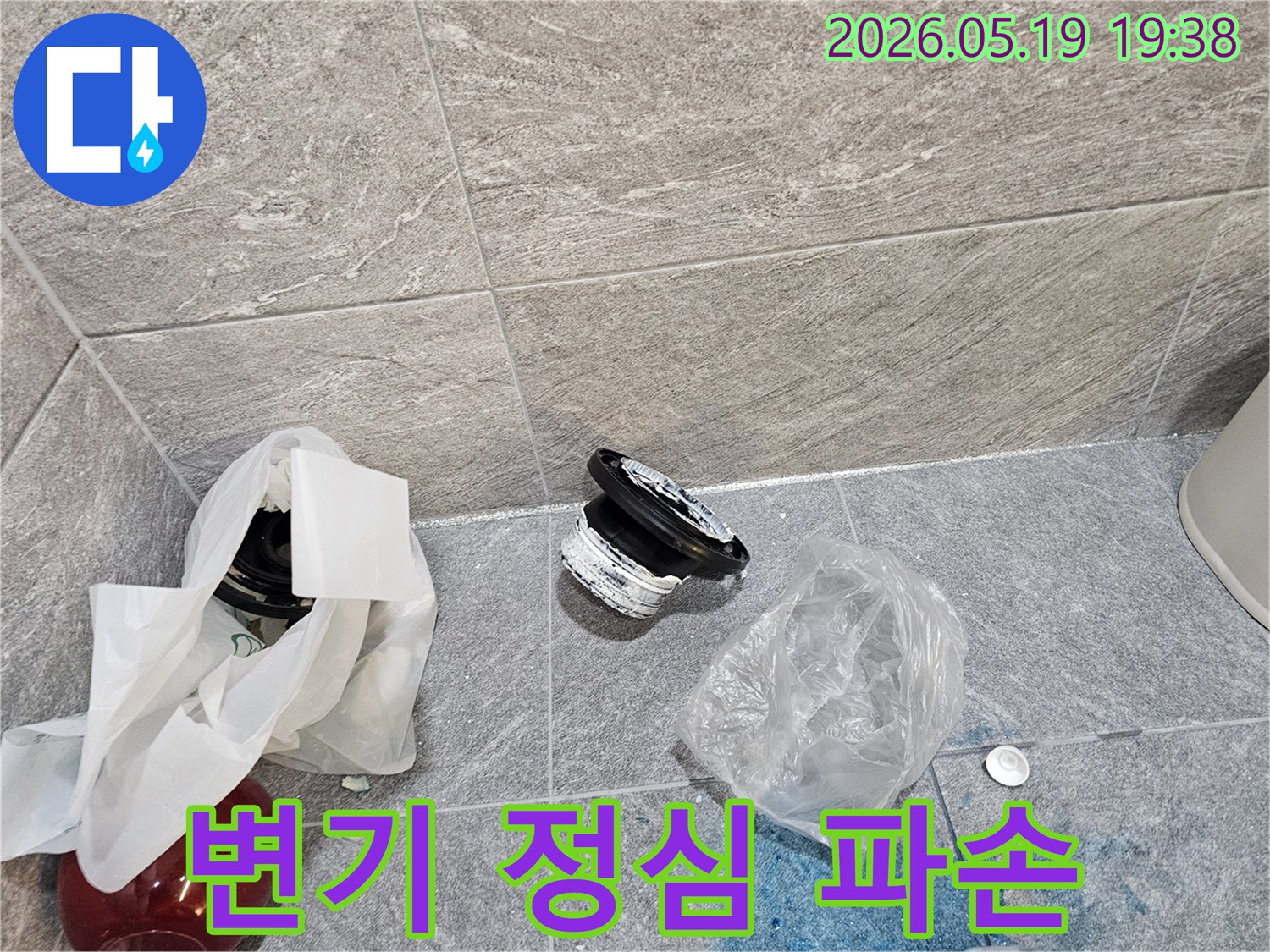 욕실 바닥에 버려진-오래된 변기 정심과-주변에 퍼진 푸른색 오염 물질