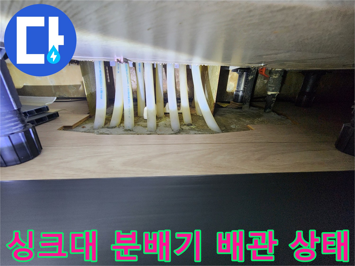 송파구 아파트 싱크대 하단 보일레이 분배기 및 흰색 배관 연결 부위 모습