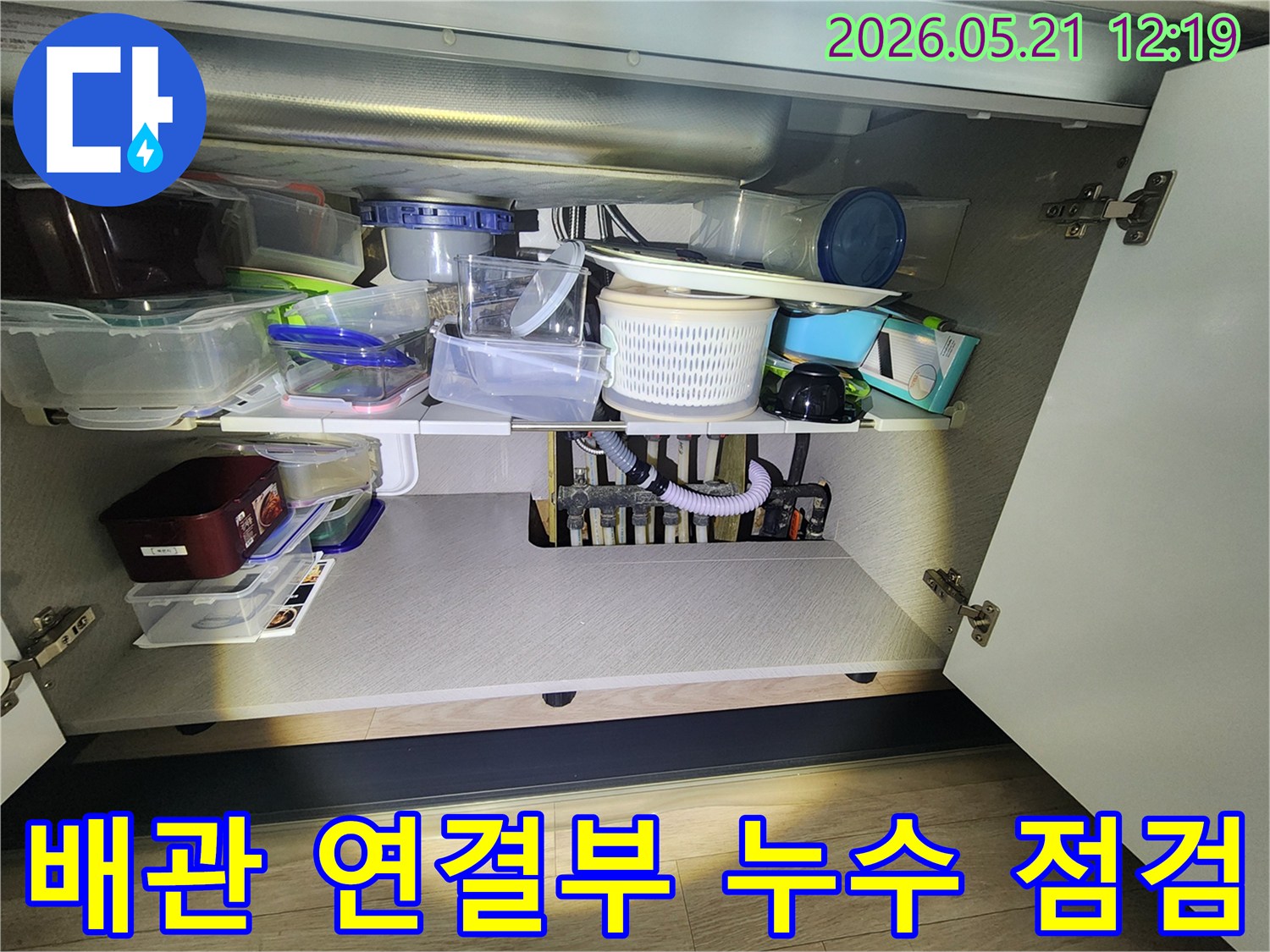 싱크대-아래-배관의-연결-부위에서-발생한-누수-여부를-전문가가-점검하는-모습입니다