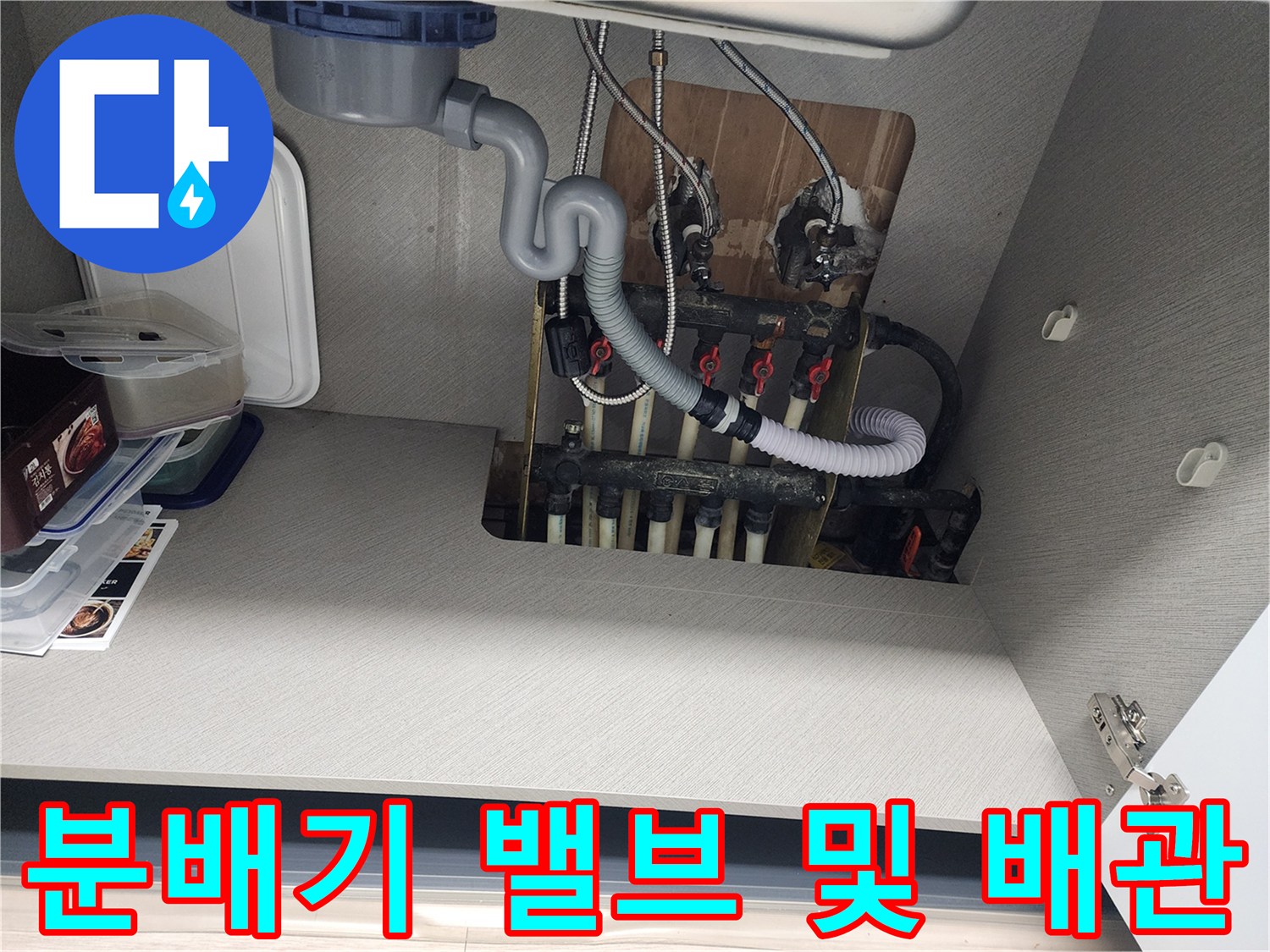 싱크대 아래쪽-보일러 분배기와 흰색 배관 구조