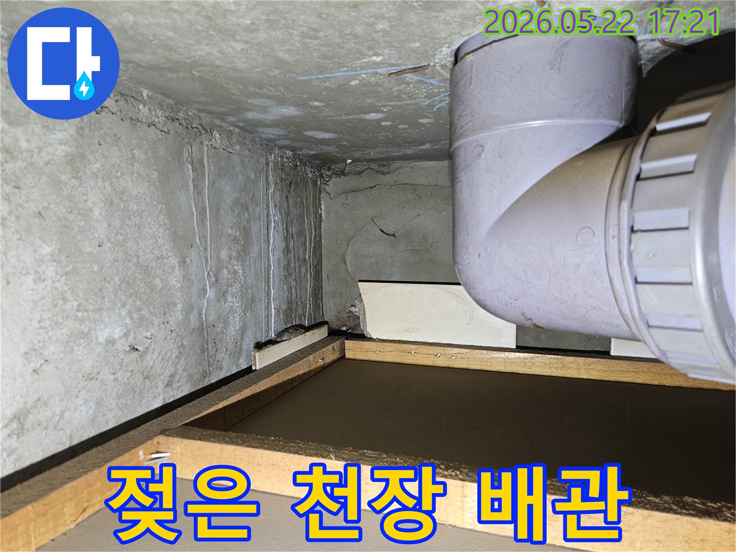 아파트 천장 모서리 부분에 나타난 물 얼룩과-배관 주변의 습기로 인한 누수 상황을 담고 있습니다.