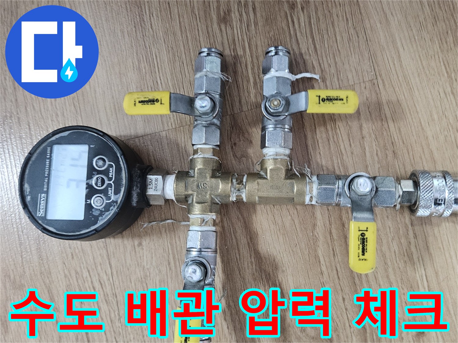 측정 장비와 노란색 급수 호스가 연결된 배관 설비