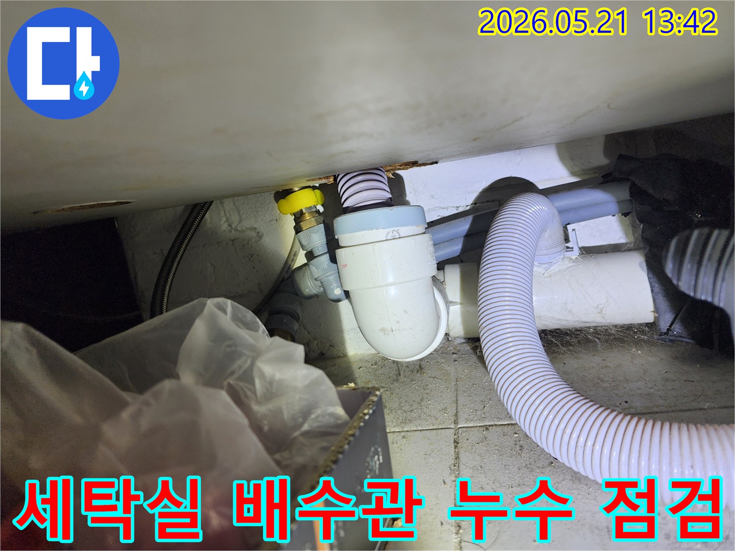 세탁기 하부 배수관과 급수 밸브가 연결된-누수 점검 현장 사진입니다.