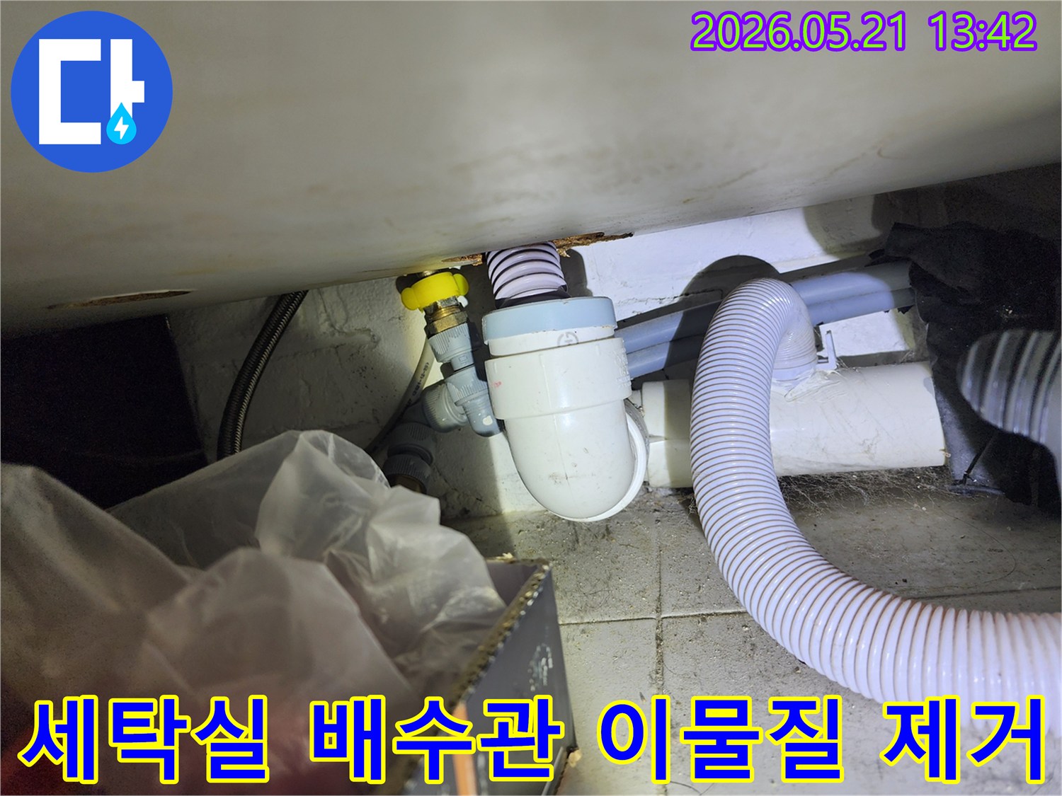 세탁실 배수관 내부에 쌓인 이물질을 깨끗하게 제거하여-배수 기능을 정상화하는 배관 청소 작업 현장입니다.