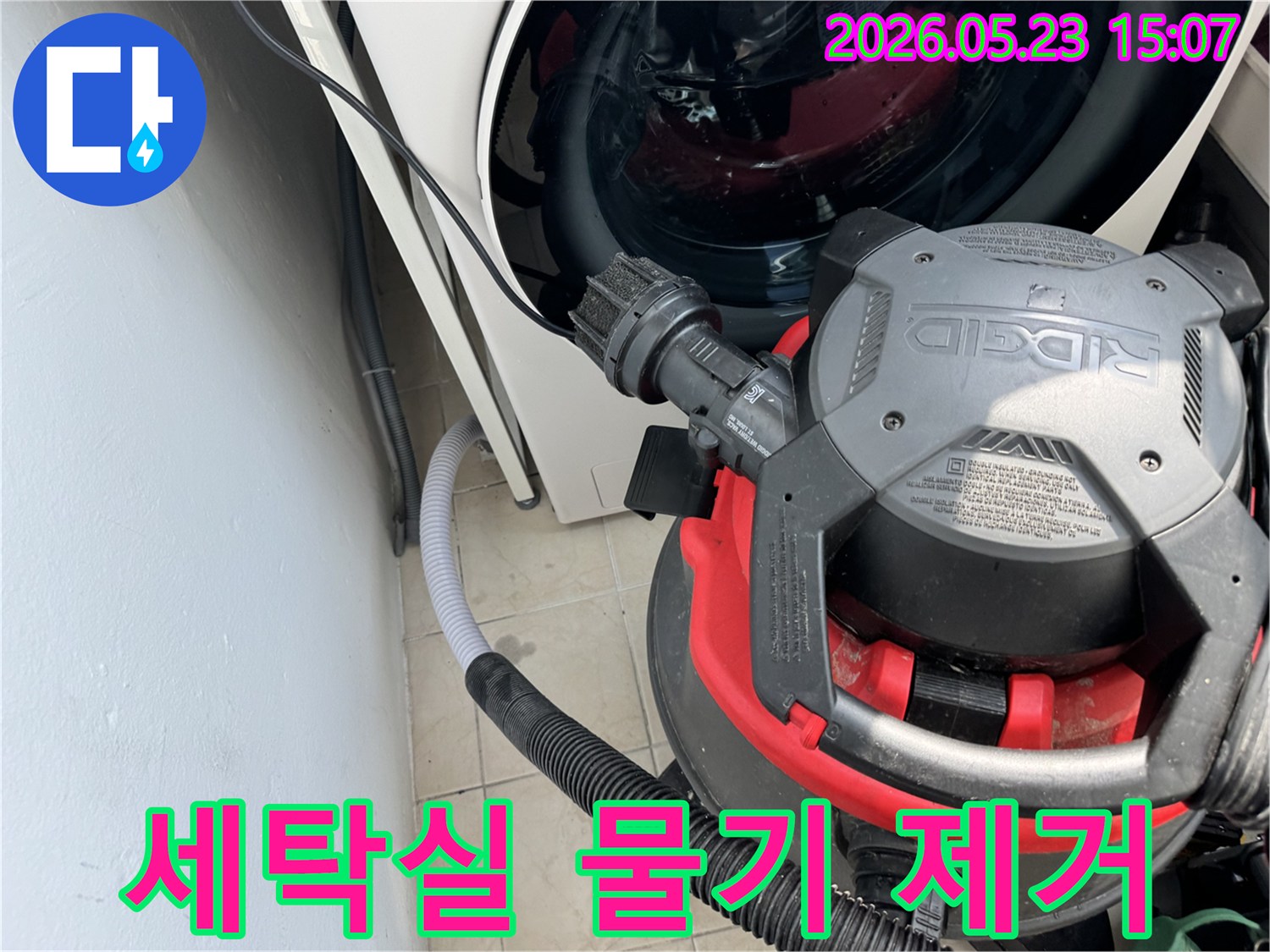 세탁기 옆-배수관 주변의 물기를-강력한 흡입기로 제거하는-누수 복구 현장 사진입니다