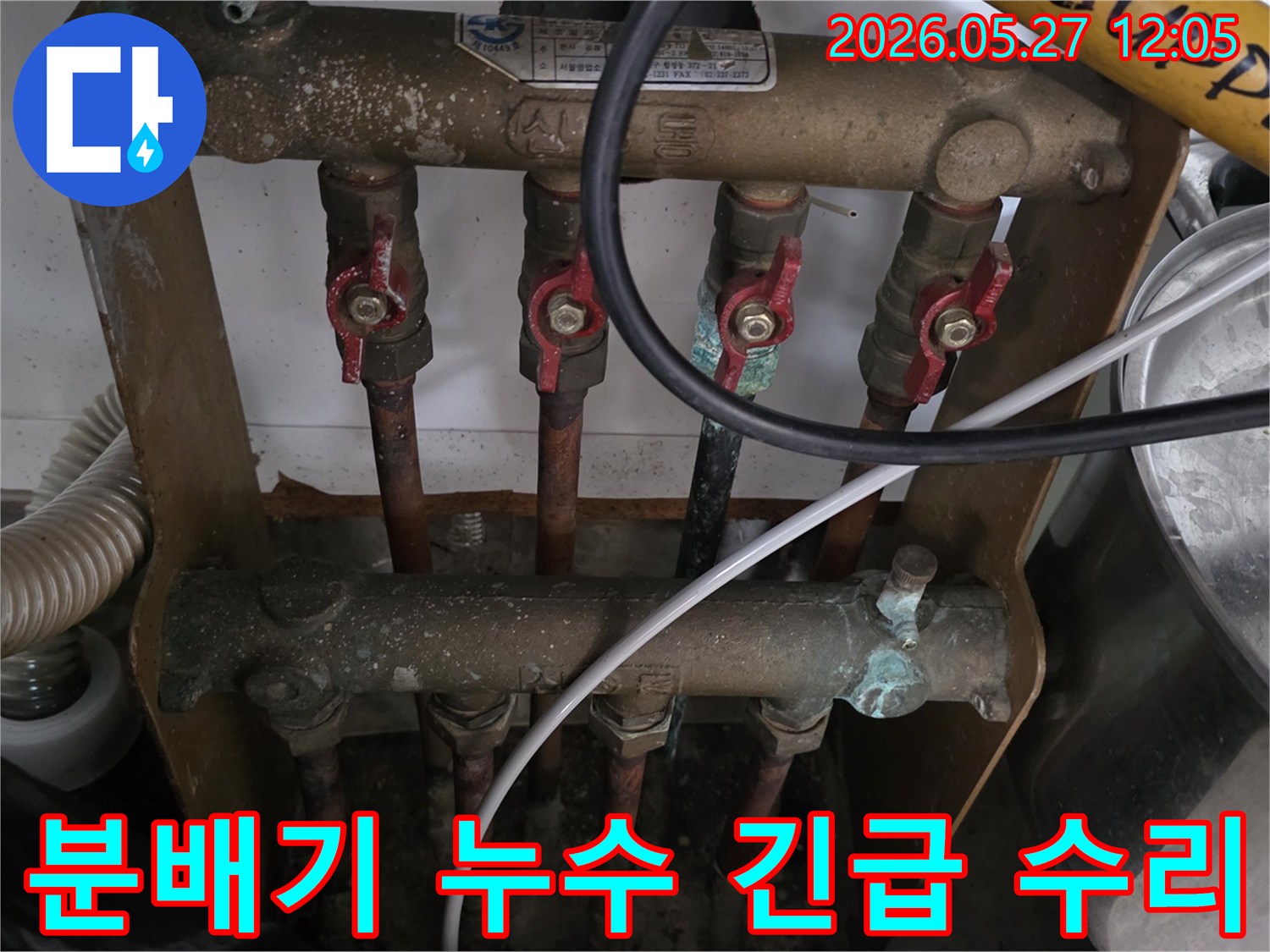 오래된 아파트의 보일러 분배기에서-갑작스러운 누수가 발생하여-전문가가 긴급 수리를 위해-현장을 방문한 모습입니다