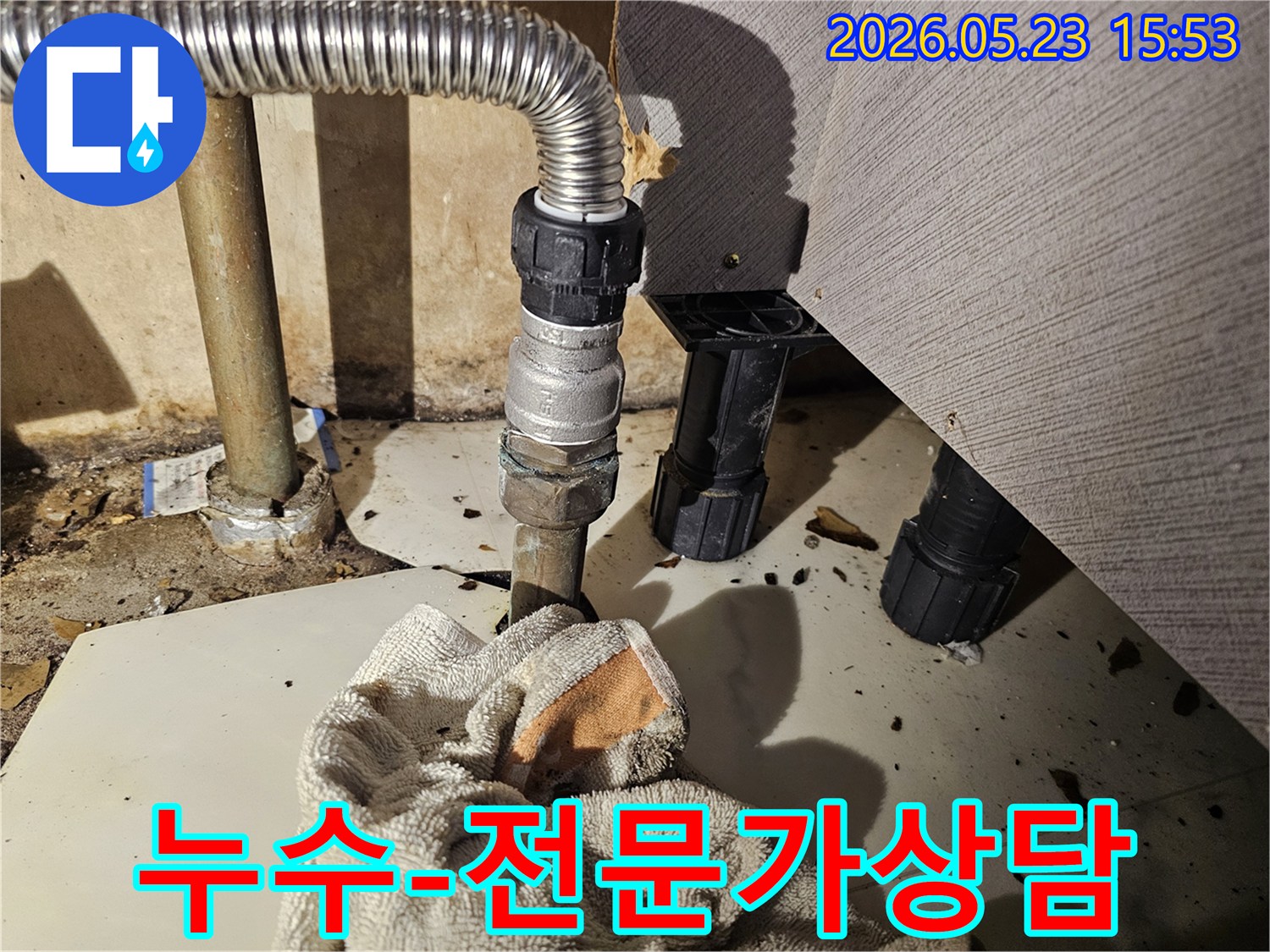 배관 연결부에서 물이 새어-바닥에 젖은 수건이 놓인-누수 전문가 상담 현장