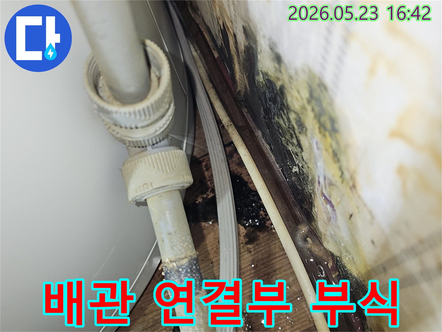 배관 연결부의 부식으로 인해-물이 새고 주변에 심각한 오염이 발생한-누수 현장 사진입니다.