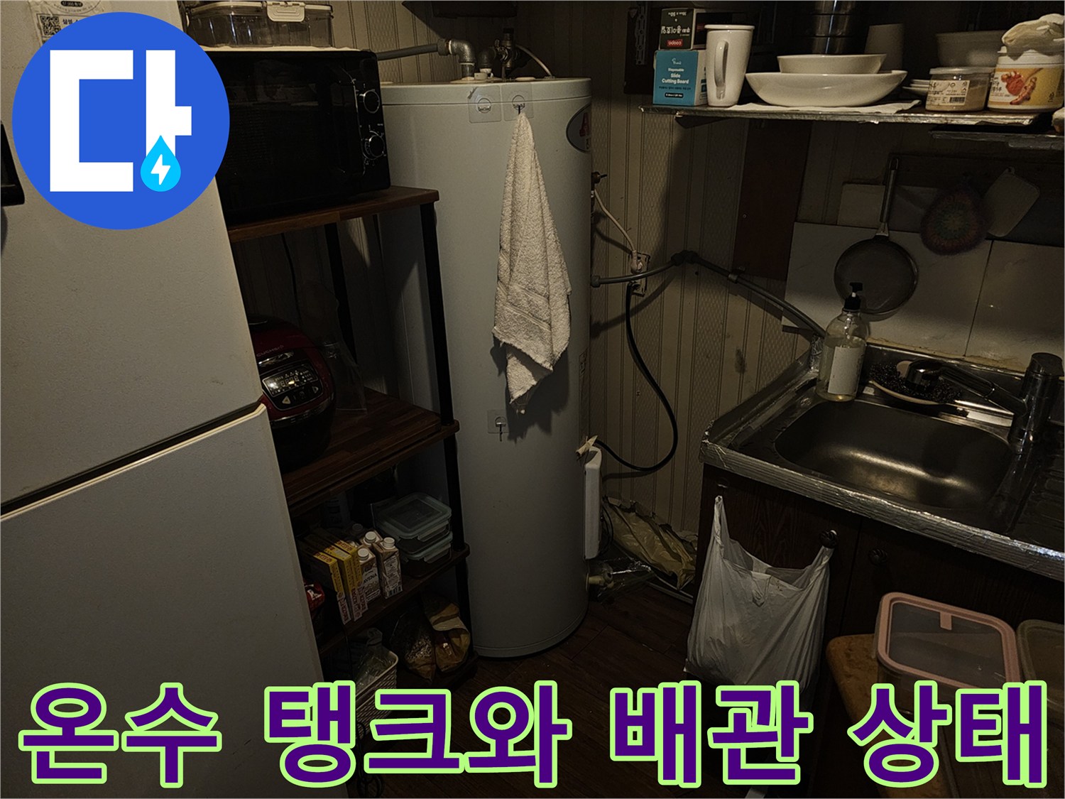 전기온수기 하단 연결 부위의 노후된 배관과 주변 집기류 모습입니다.