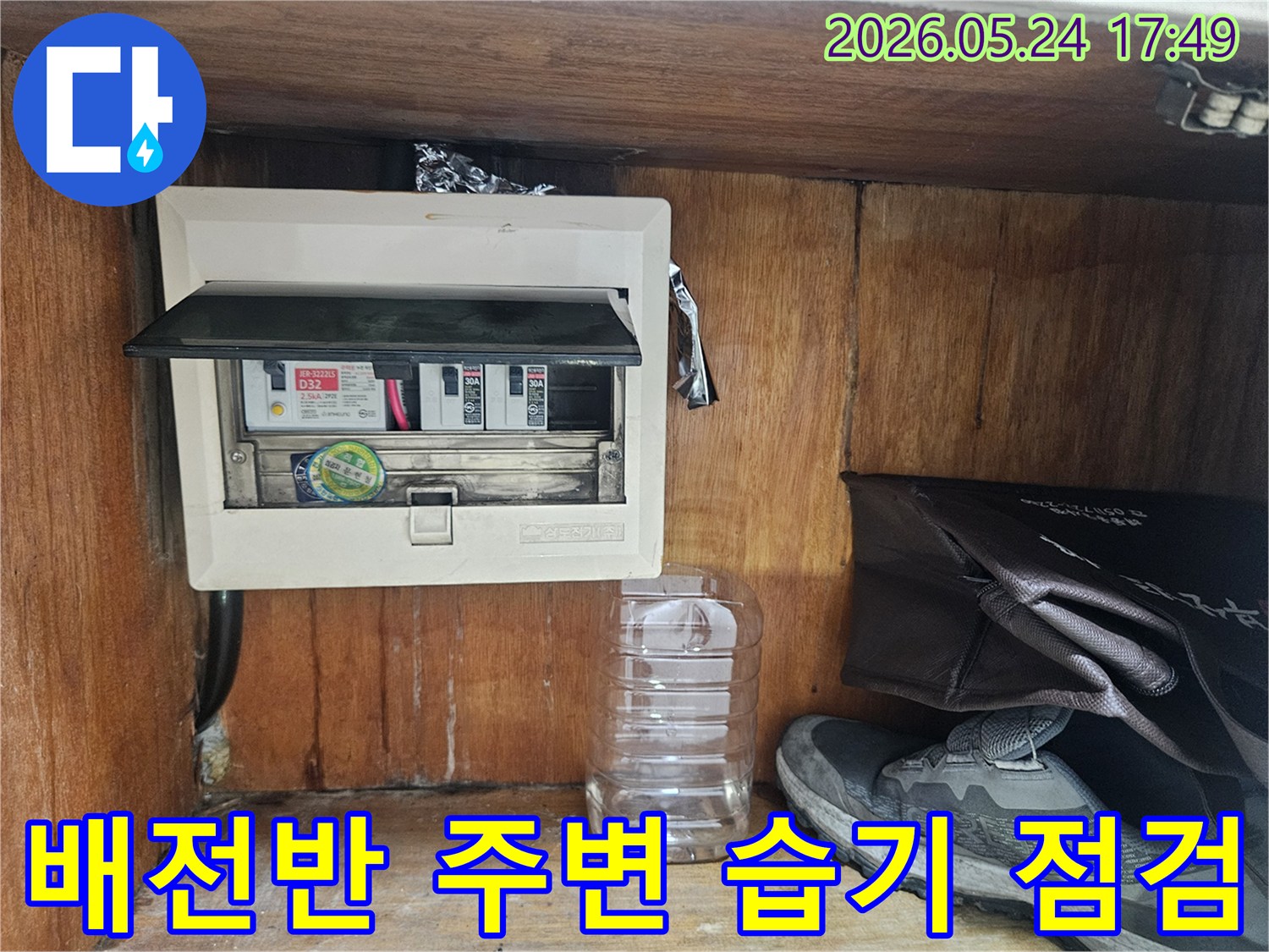 누수 전문가가 전기 배전반-주변의 습기 여부를 꼼꼼하게 점검하는 장면입니다.