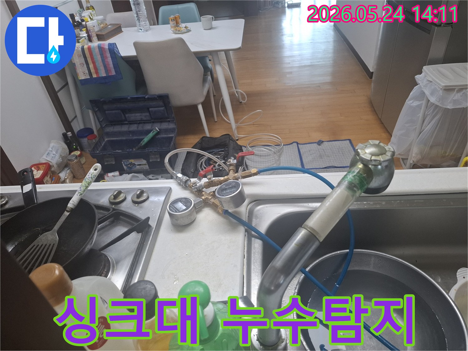 싱크대에서 누수 탐지 장비를 연결하여 배관 상태를-정밀하게-점검하는-모습입니다