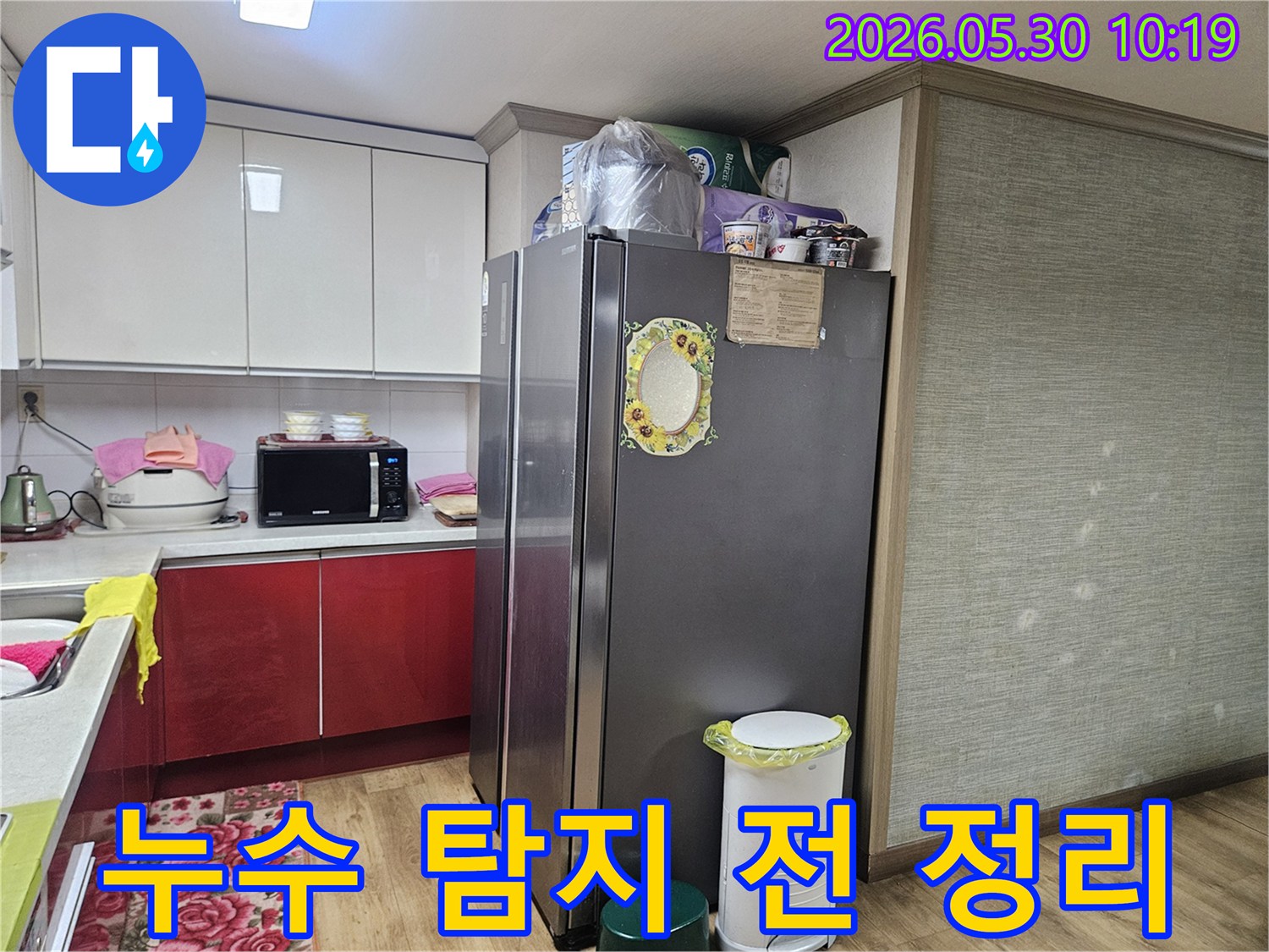 누수 엔지니어가-강동구 천호동 아파트 주방에서-누수 탐지 작업을 위해-주변 물건들을 정리하고 있습니다