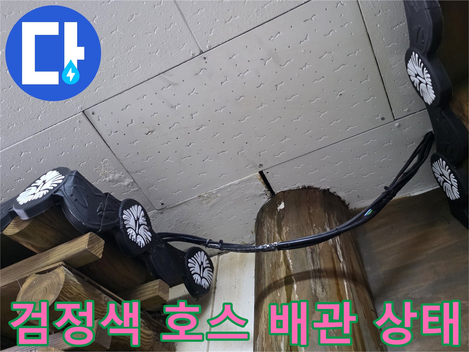 천장 구조물과 기둥 사이에 연결된 검은색 고압 호스 부위