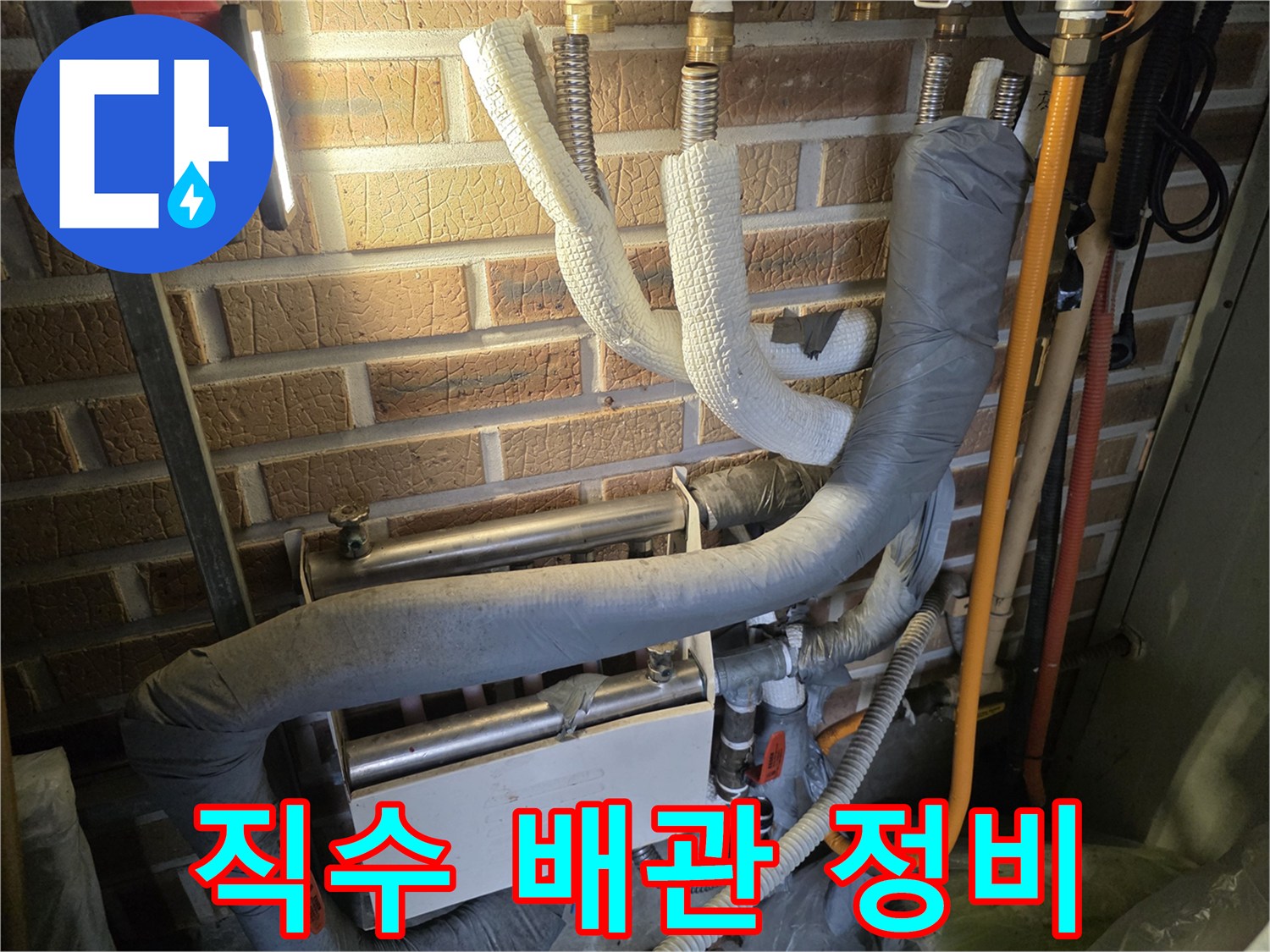 보온재로 마감된 직수 배관과 분배기 연결 부위의 근접 사진