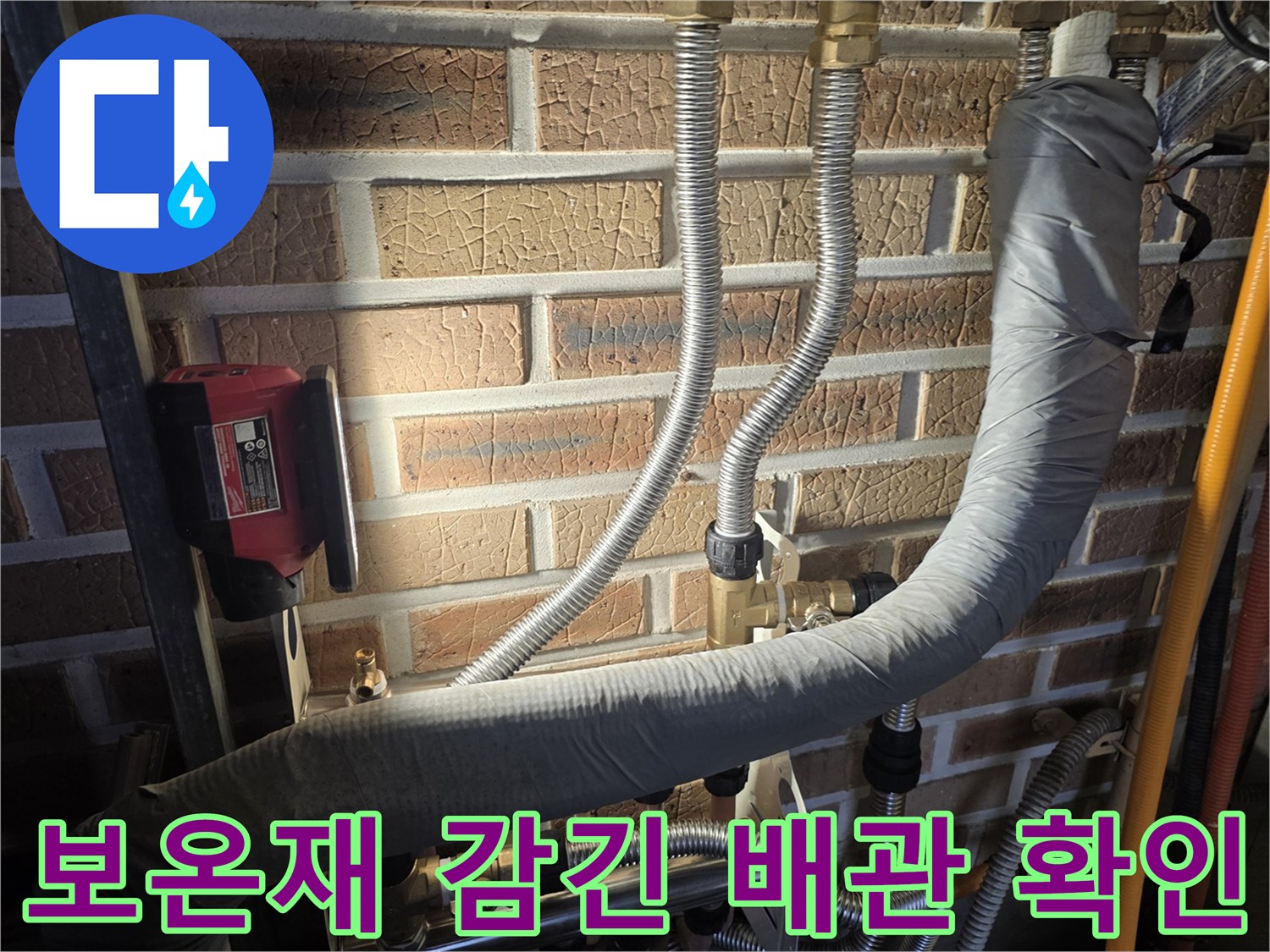 회색 보온재로 덮인 대형 배관과 은색 주름관 연결 부위