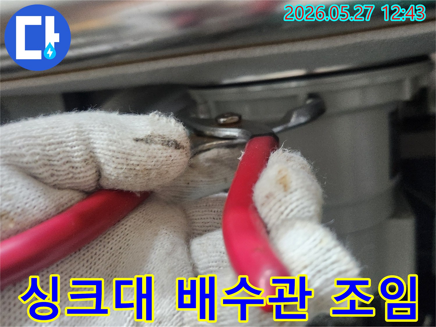 싱크대-배수관-연결부에서-발생한-누수를-전문가가-공구를-사용해-조이는-사진입니다