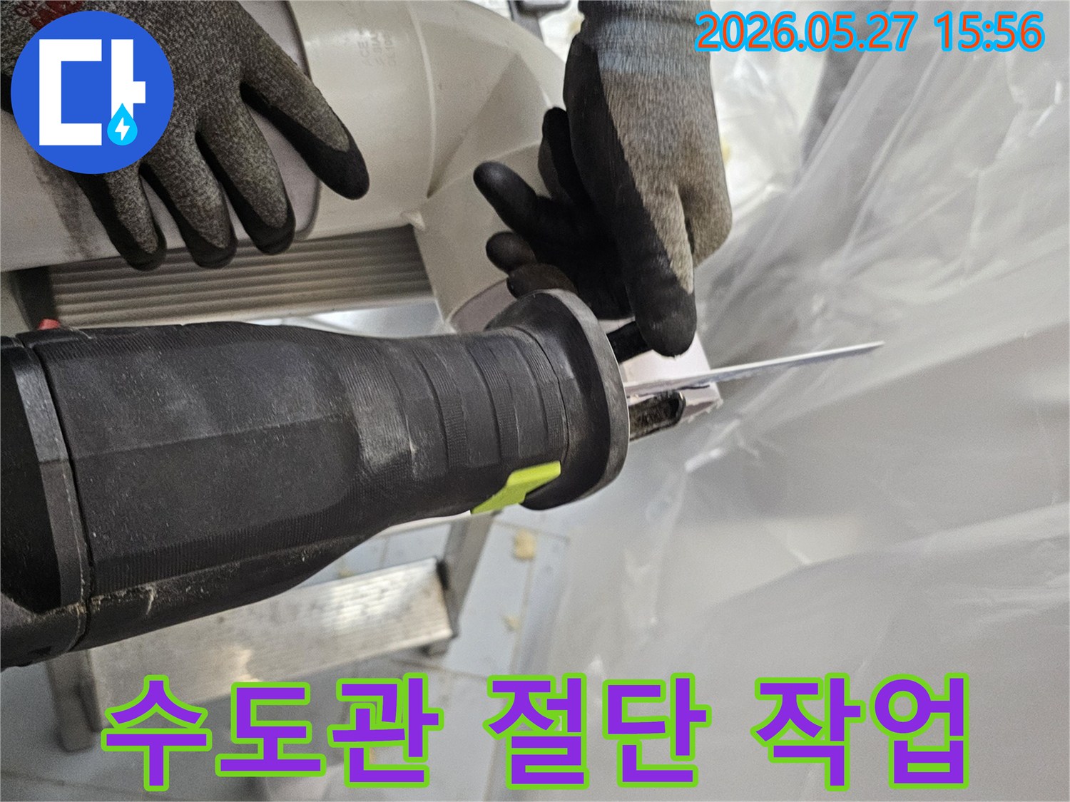 전문-작업자가-안전장갑을-착용하고-전기톱으로-수도관-PVC-파이프를-정밀하게-절단하고-있습니다