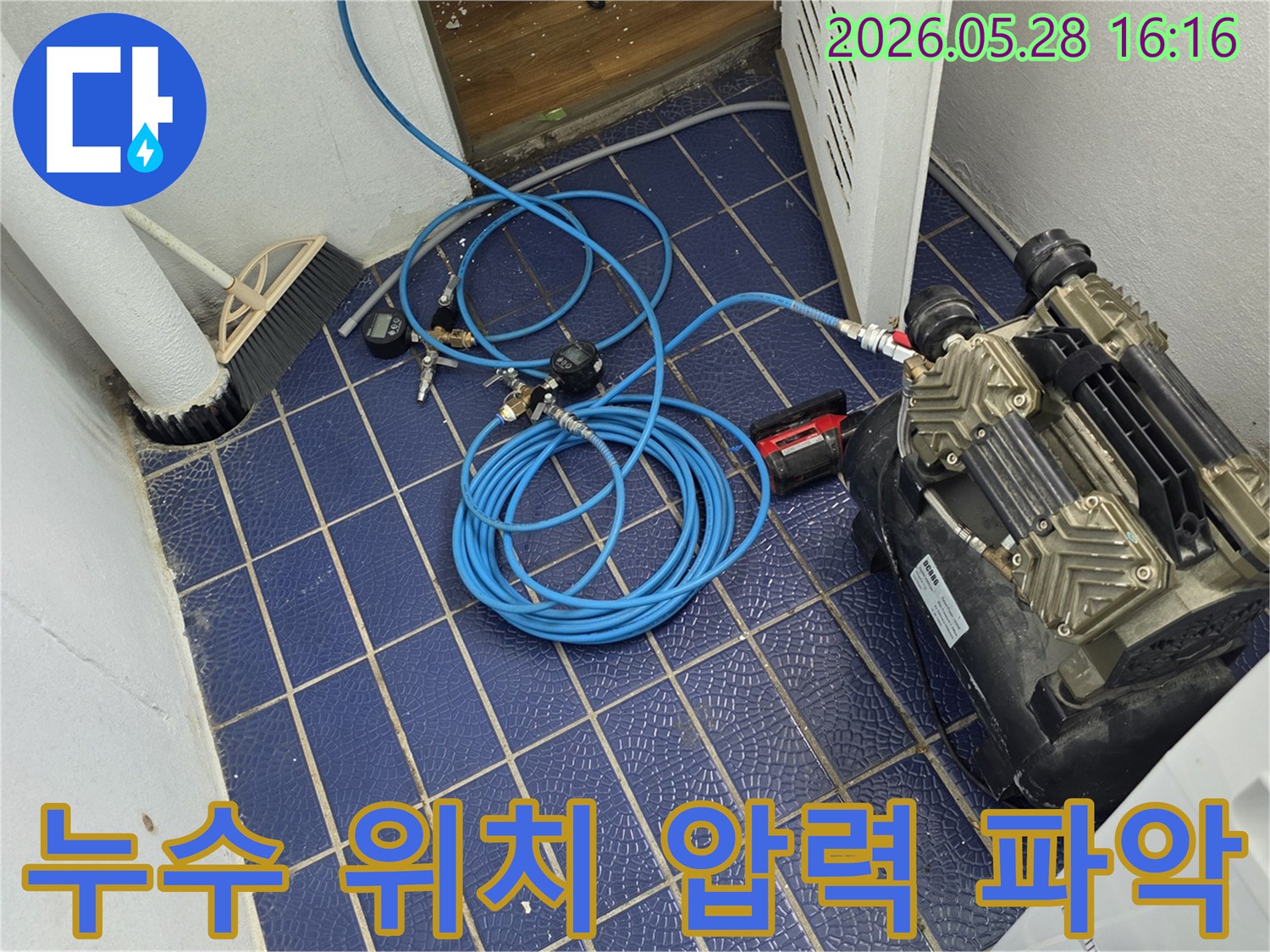 누수-위치를-파악하기-위해-배관에-연결된-공압-장비와-압력-게이지-그리고-파란색-호스가-보이는-작업-현장