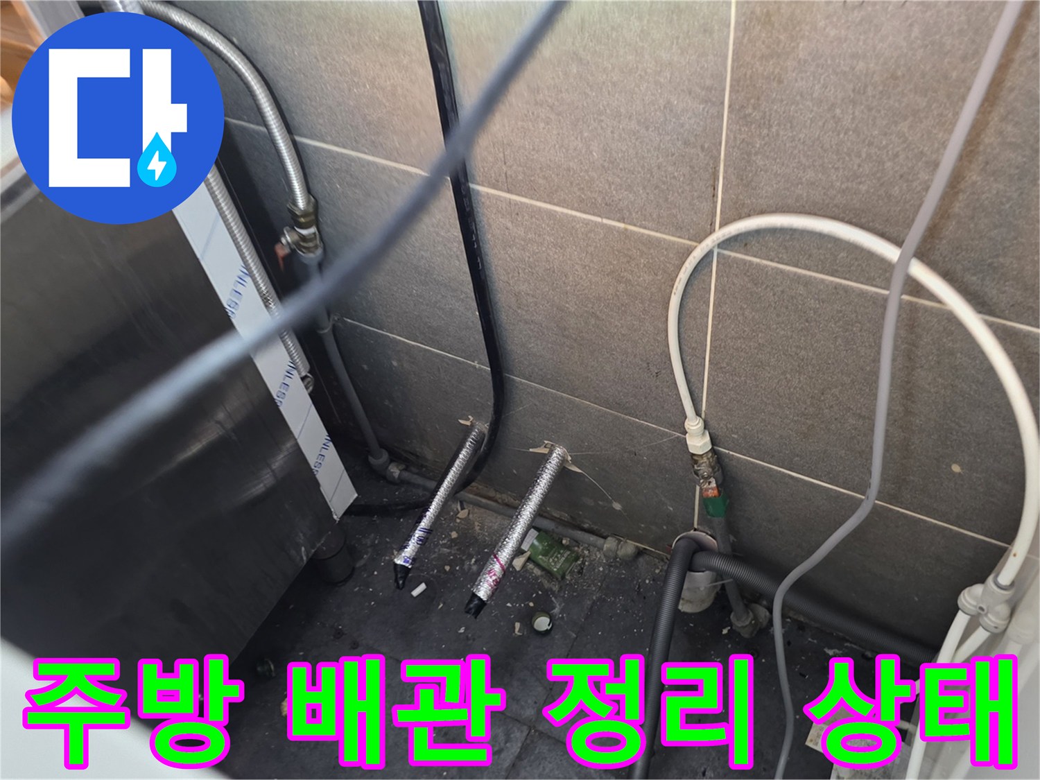 식당 주방 하단에 복잡하게 얽혀 있는 냉온수 배기 및 호스 연결 부위