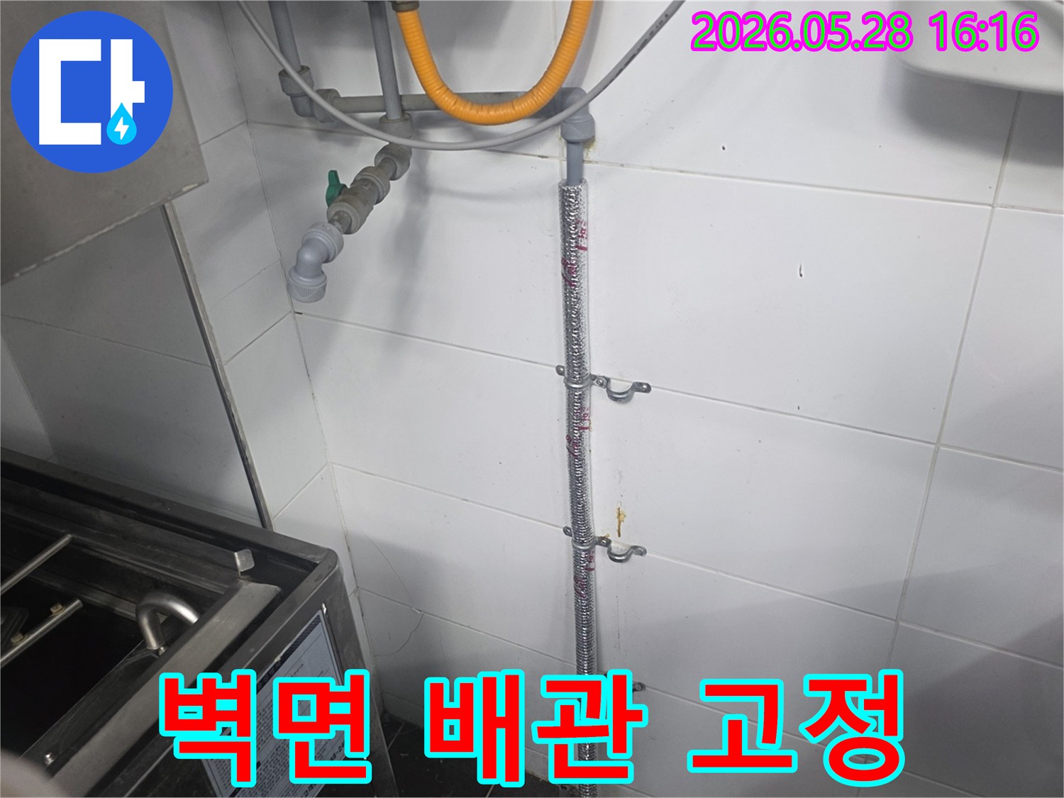 오래된 듯한 타일 벽에-견고하게 고정된 수도 배관-가스관과 나란히 설치된 모습-누수 여부를 확인하기 위한 육안 검사