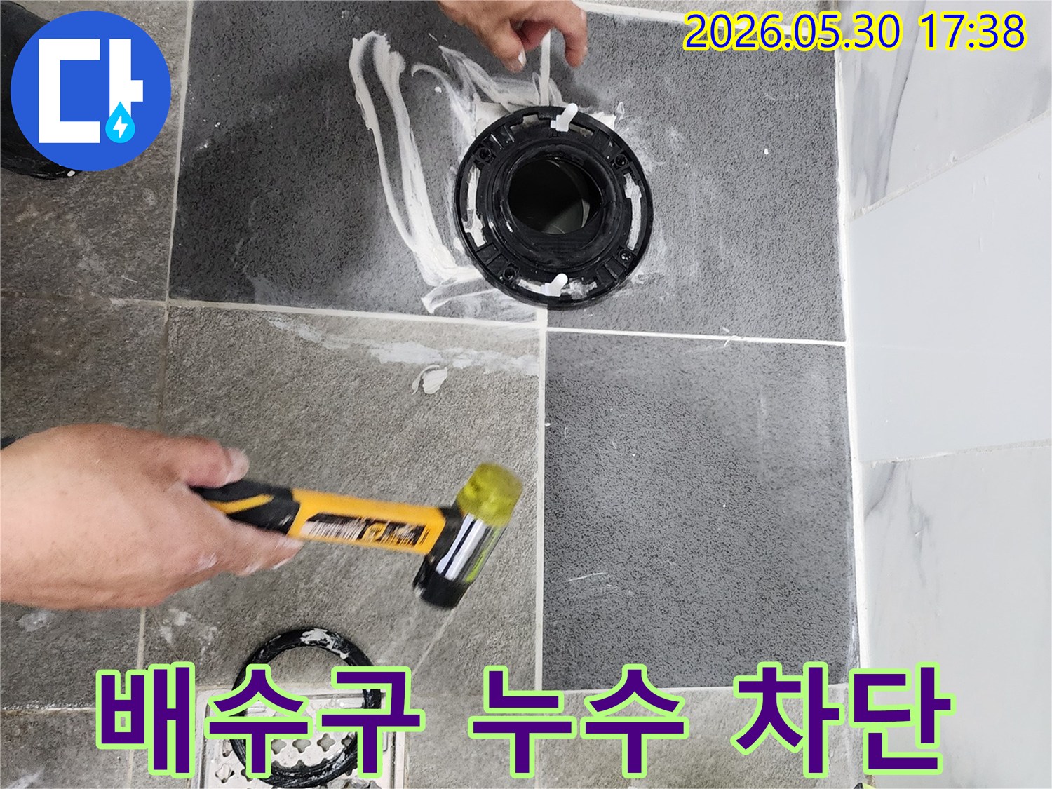 욕실 바닥의 배수구 주변과-변기 플랜지 연결 부위를-누수 방지를 위해-전문가가 꼼꼼하게 실링하고 있습니다.