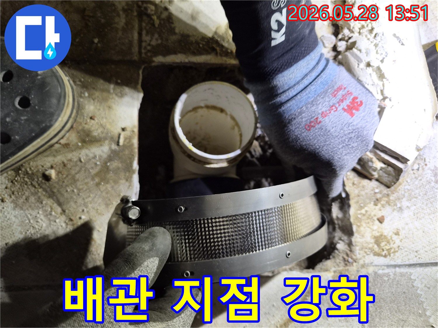 전문가가 작업용 장갑을 끼고-누수 발생 배관 부위에-보강 밴드를 적용하는 모습입니다